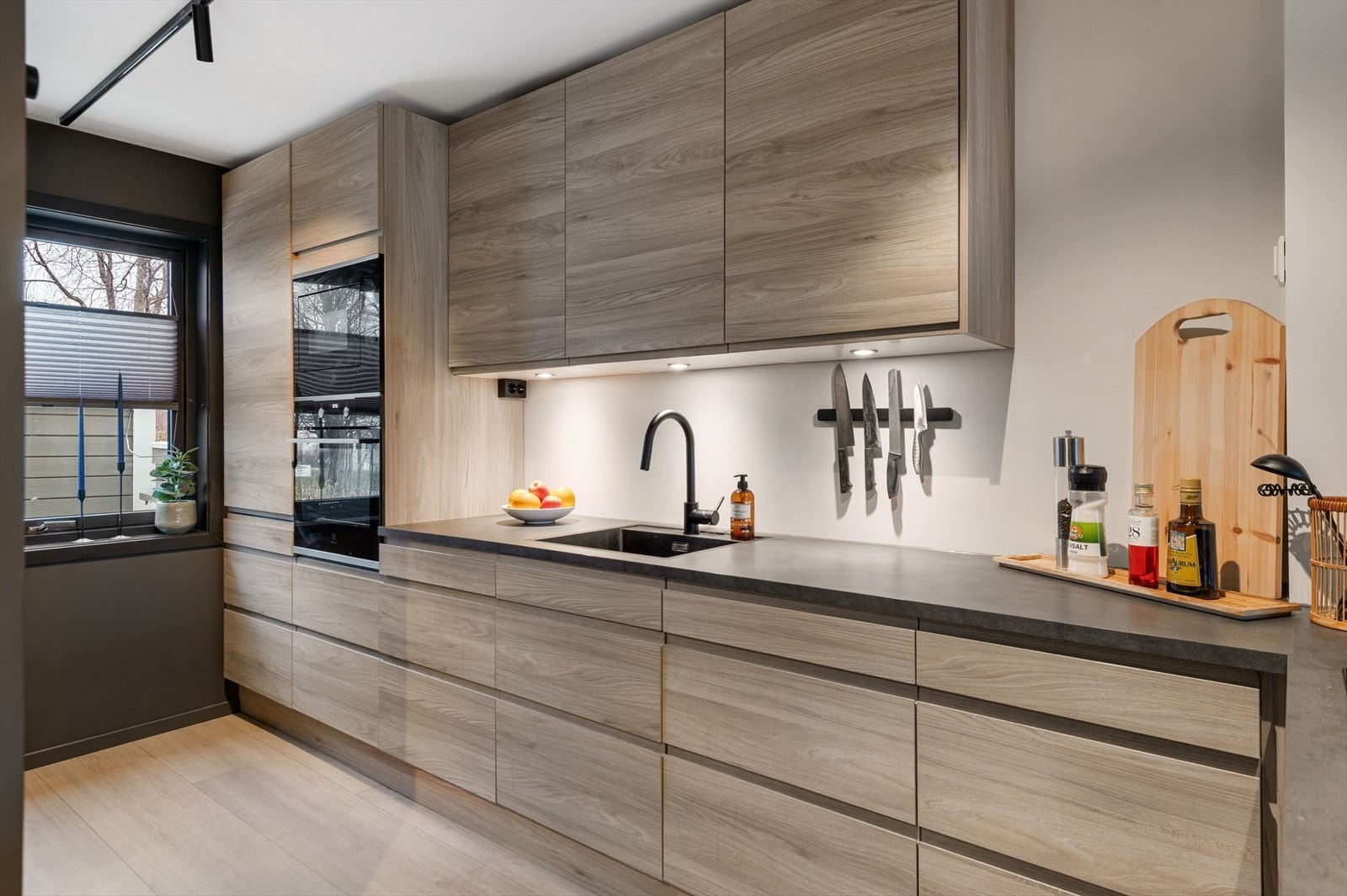 Stilrent kjøkken med god benkeplass og integrerte hvitevarer. Galleribilde