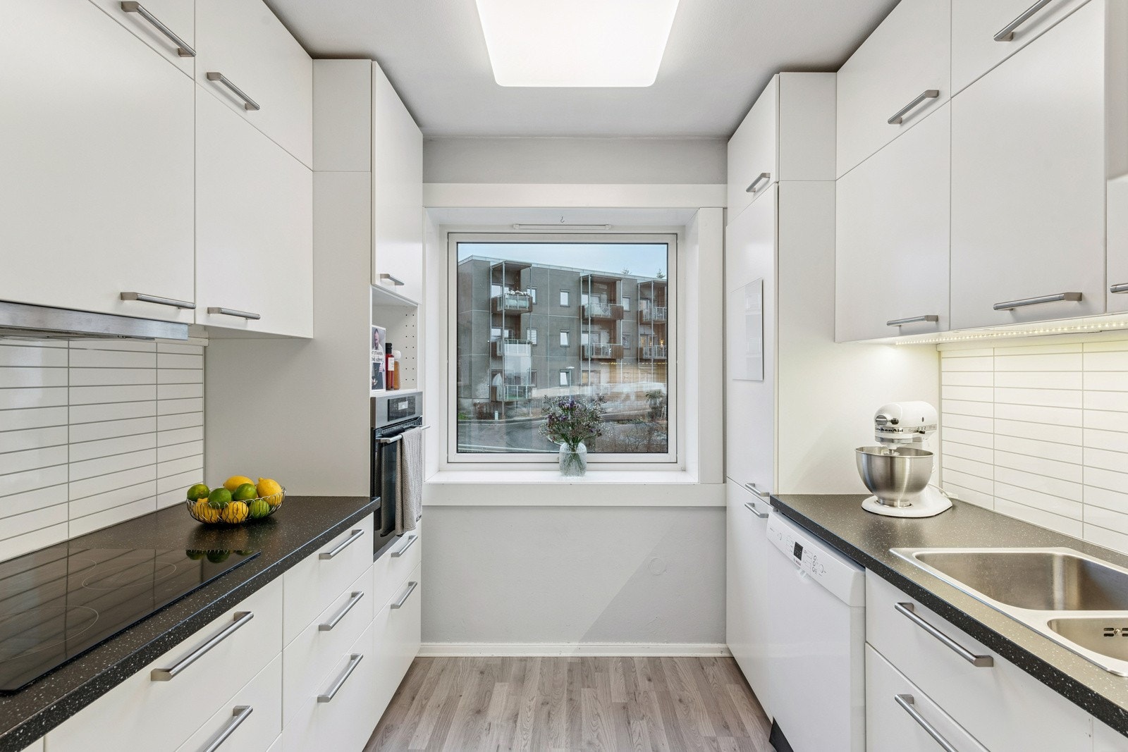 Kjøkkeninnredning fra IKEA med glatte, stilrene fronter og laminert benkeplate. En praktisk og funksjonell løsning med god skap- og benkeplass. Galleribilde