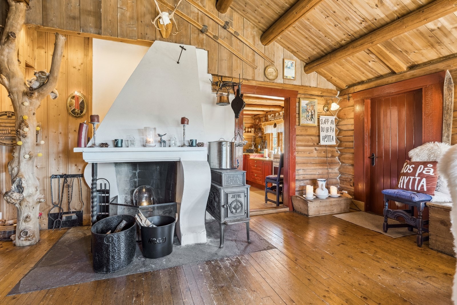 En åpen peis gir en hyggelig stemning til rommet. Nær peisen er det en større vedovn som sørger for lun og god varme. Galleribilde