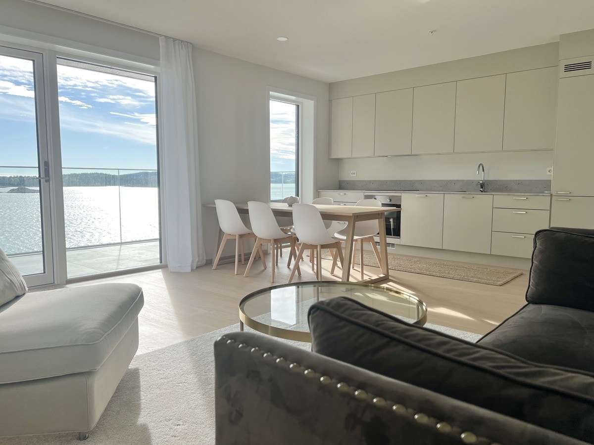 Åpen stue/kjøkkenløsning med sjøutsikt og ut gang til balkong. Galleribilde