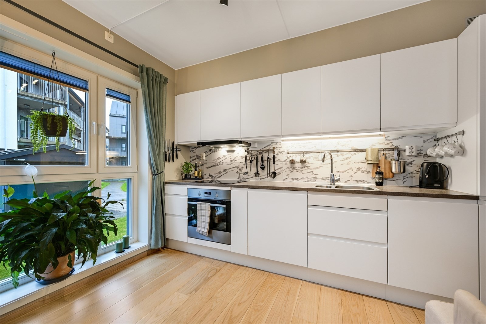 Pent kjøkken med integrerte hvitevarer som medfølger. Galleribilde