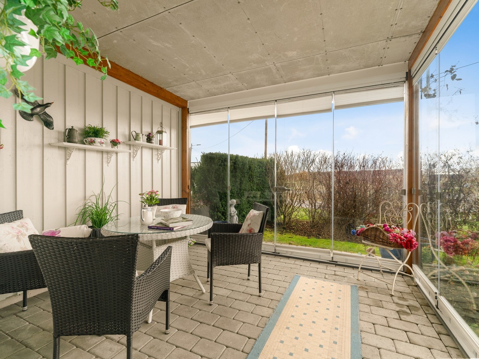 Terrassen er inn-glasset med steinsatt gulv. Skyvedører ut mot hage. Galleribilde