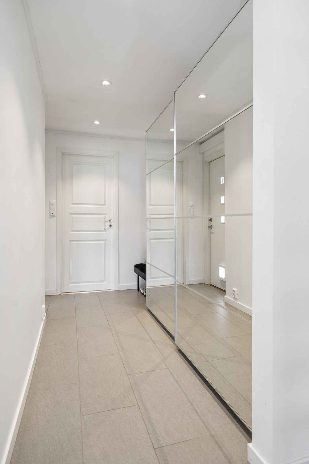 Entréen gir et meget godt førsteinntrykk av rekkehuset med grå gulv fliser med varmekabler og skyvedørsgarderobe Galleribilde
