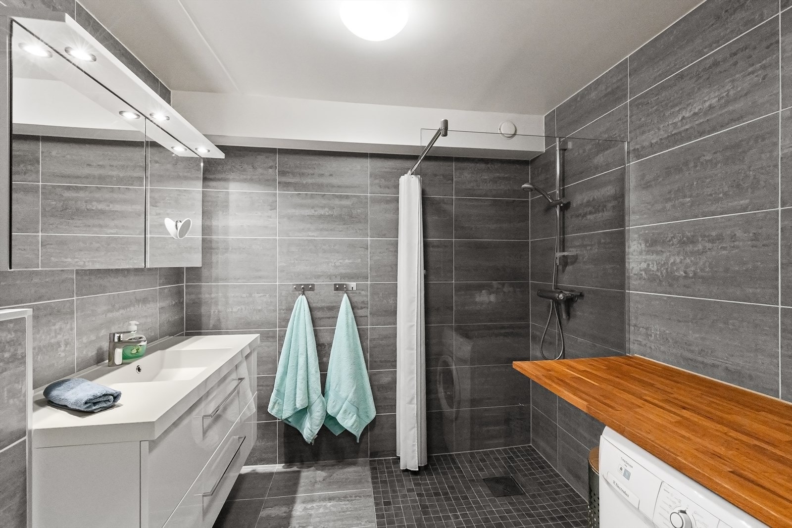 Meget pent flislagt dusbad/wc med opplegg vaskemaskin Galleribilde