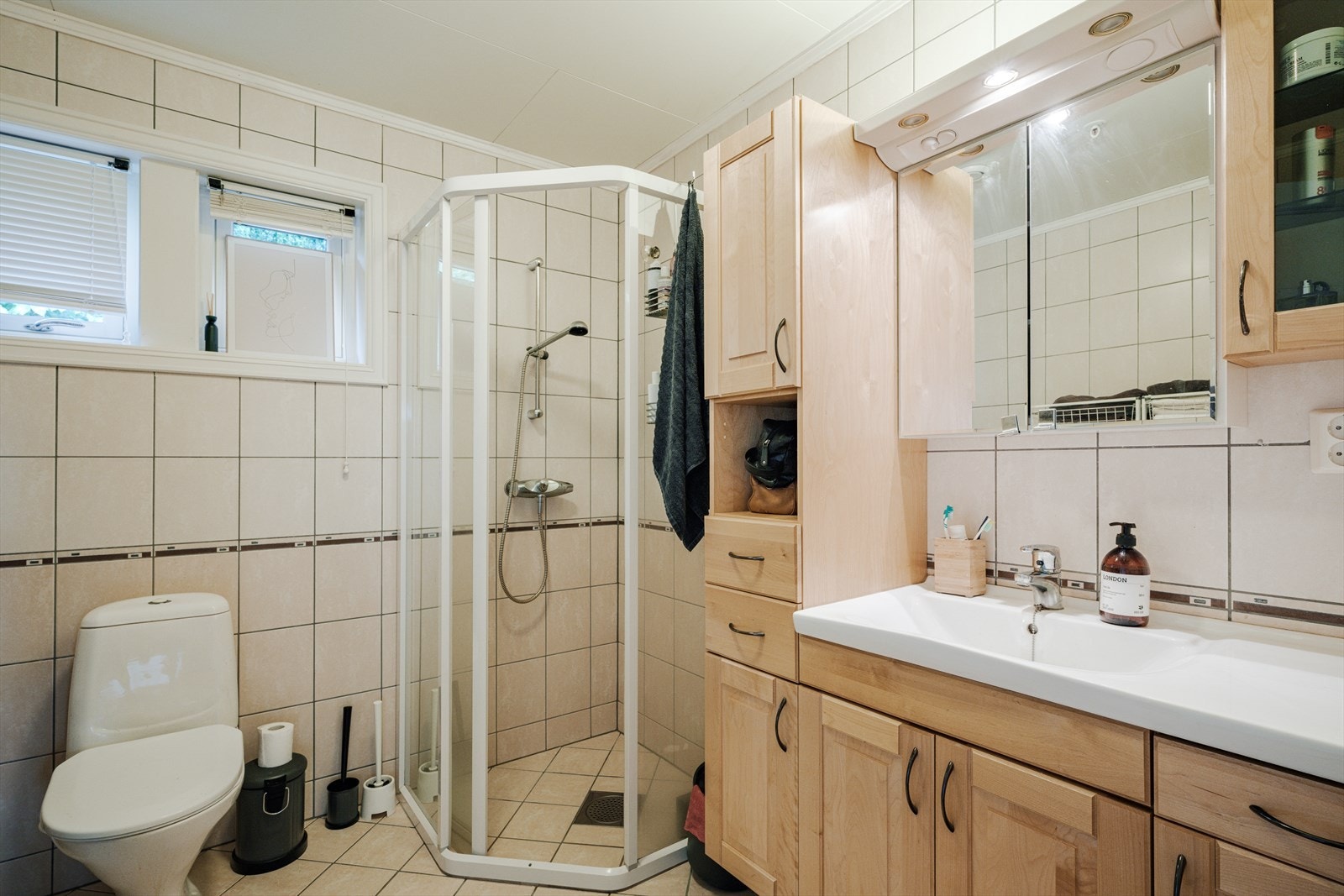 Badet i utleiedelens 2. etasje har flislagt gulv og vegger. Det er det gulvmontert klosett og dusjnisje med herdet glass. Galleribilde