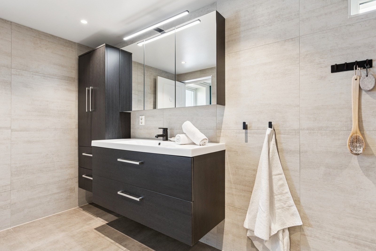 Servantskapet har en bredde på 120cm og byr sammen med den vegghengt speil- og skapløsningen på rikelig med oppbevaringsplass. Galleribilde