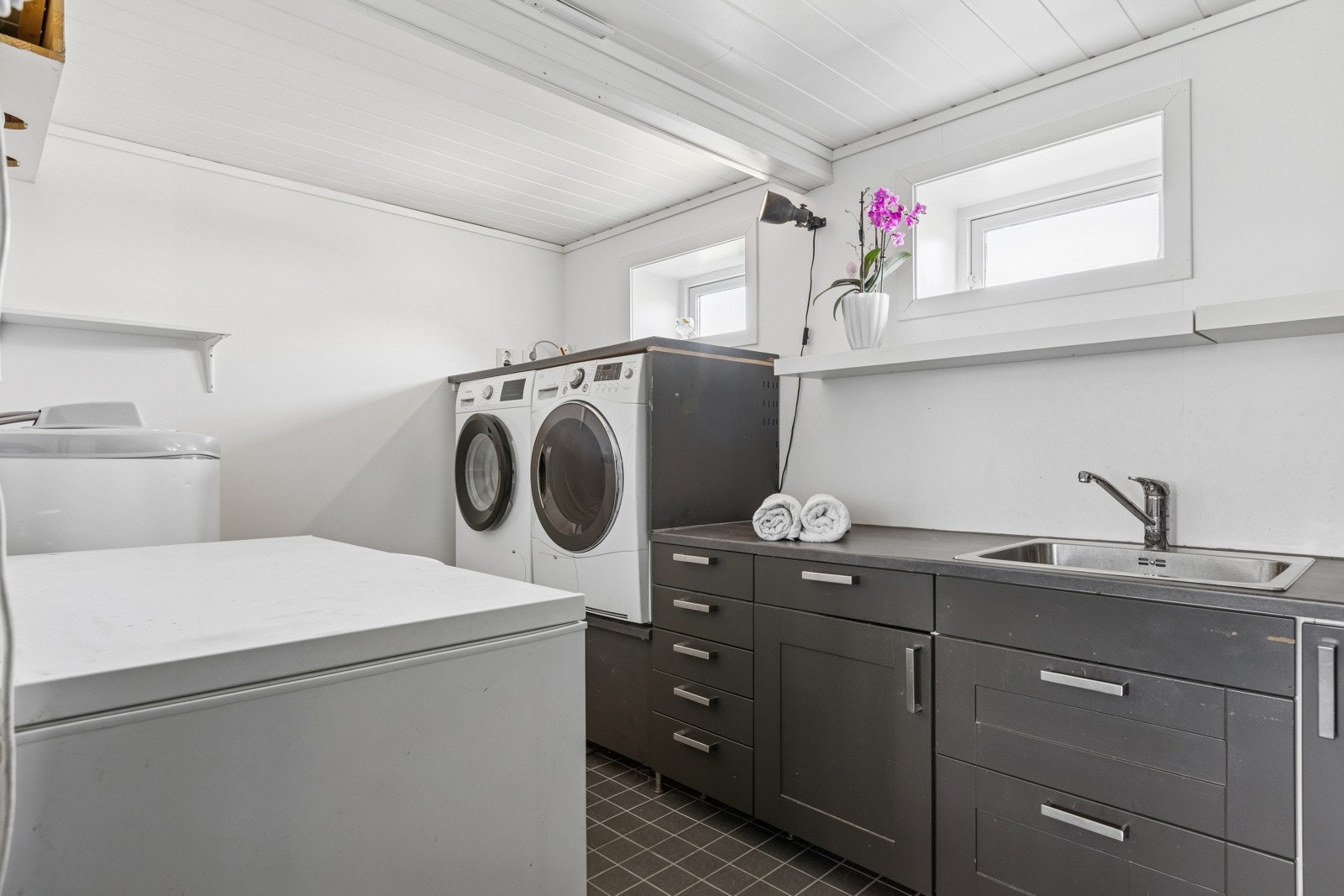Separat vaskerom med vask, benk, skuffer- og skap. Opplegg for vaskemaskin-/tørketrommel i arbeidshøyde. Galleribilde