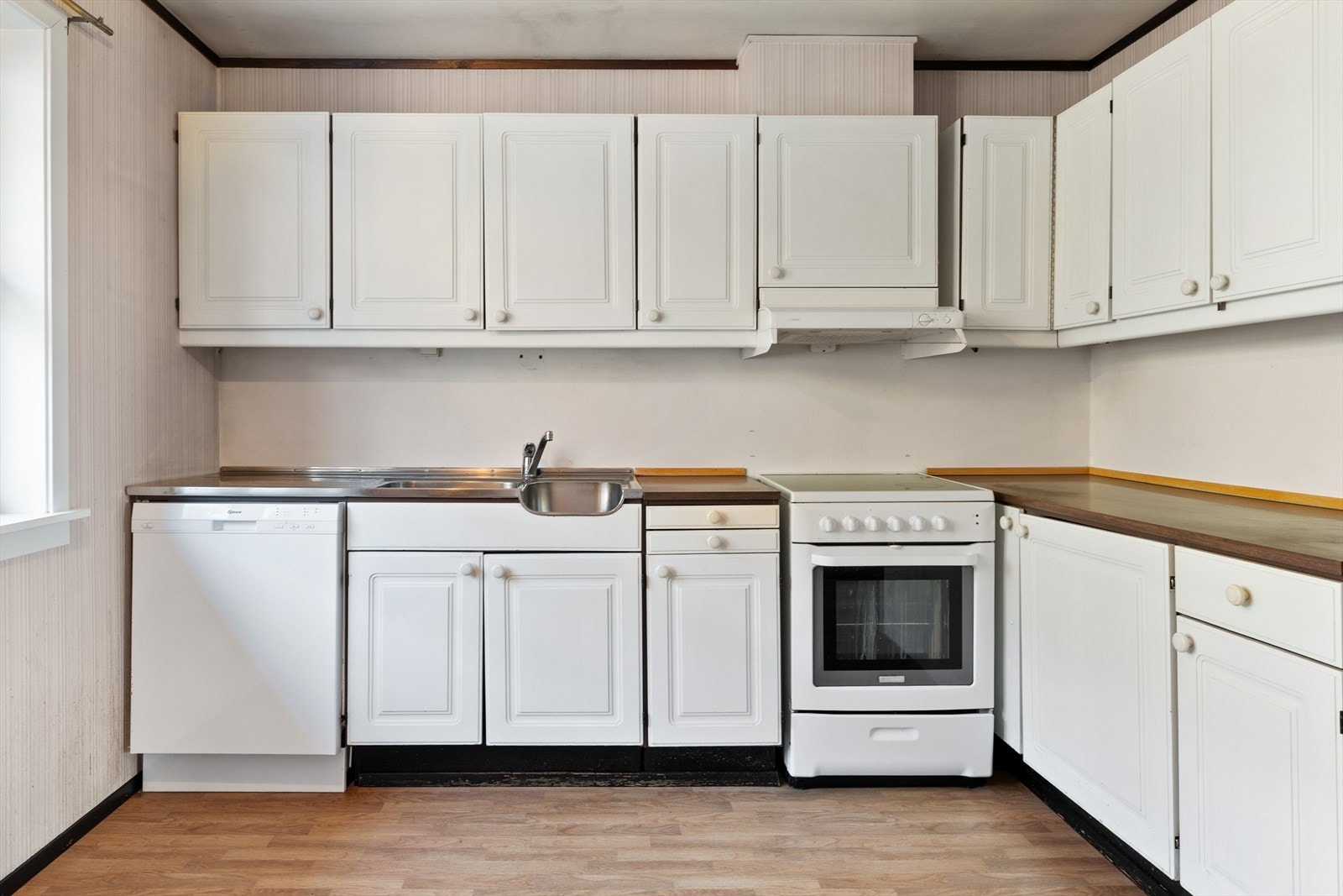 Innredningen er av eldre dato med profilerte fronter og laminert benkeplate. Det er opplegg for oppvaskmaskin og ventilator med mekanisk avtrekk. Galleribilde