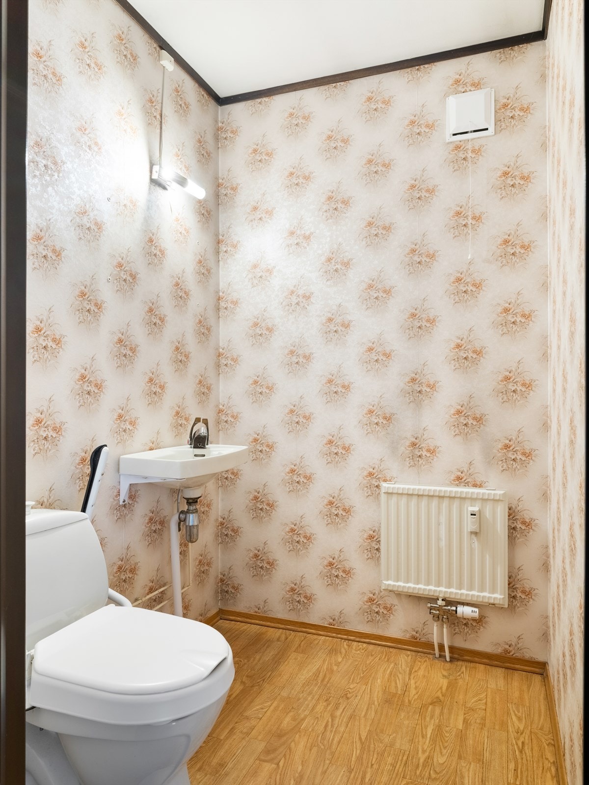 Toalettrommet ligger praktisk plassert i tilknytning til entréen. Rommet har belegg på gulv og tapet på vegger, og er utstyrt med servant og toalett. Galleribilde