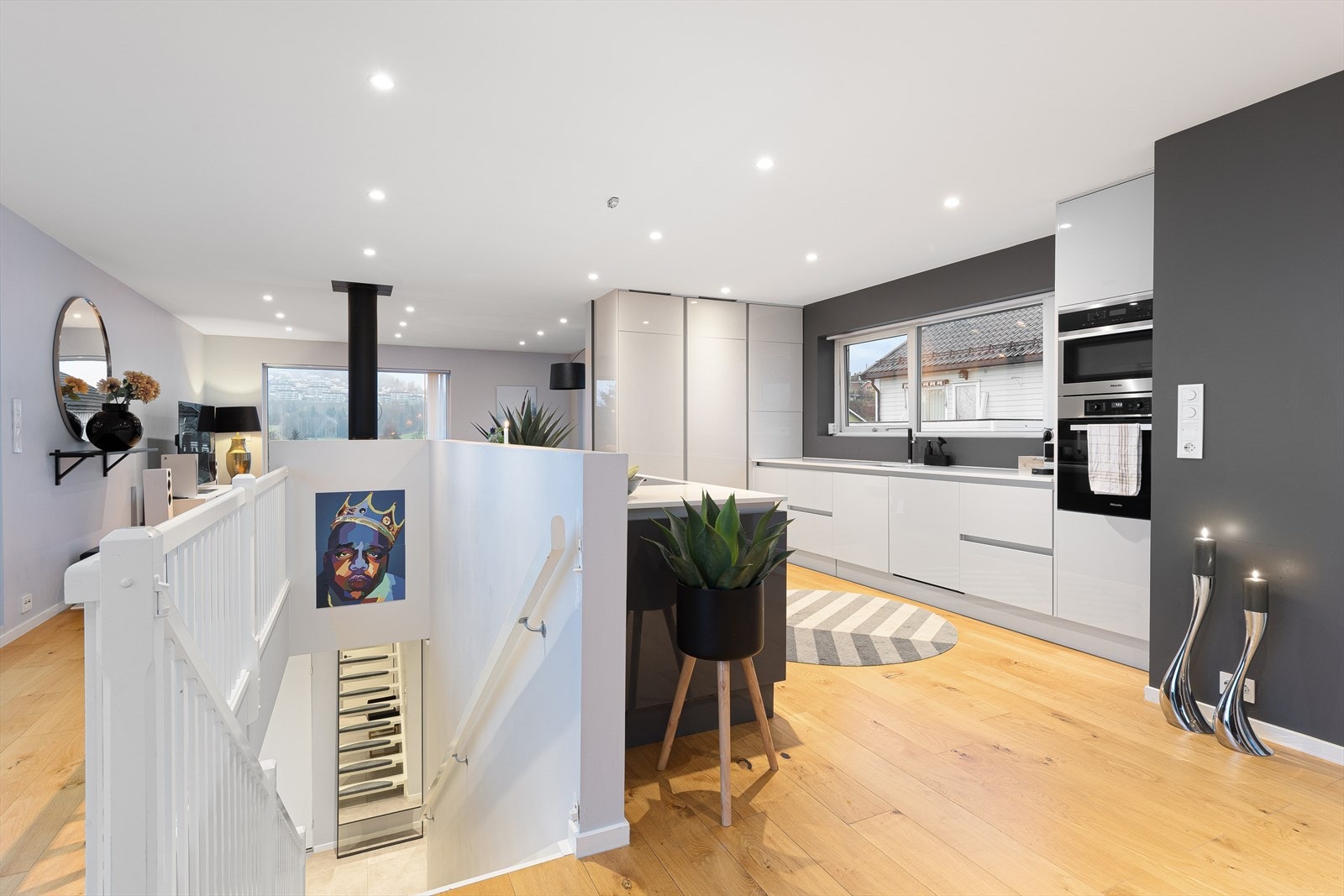 Lekkert og moderne kjøkken med lakkerte slette fronter og benkeplate i solid stein. Galleribilde