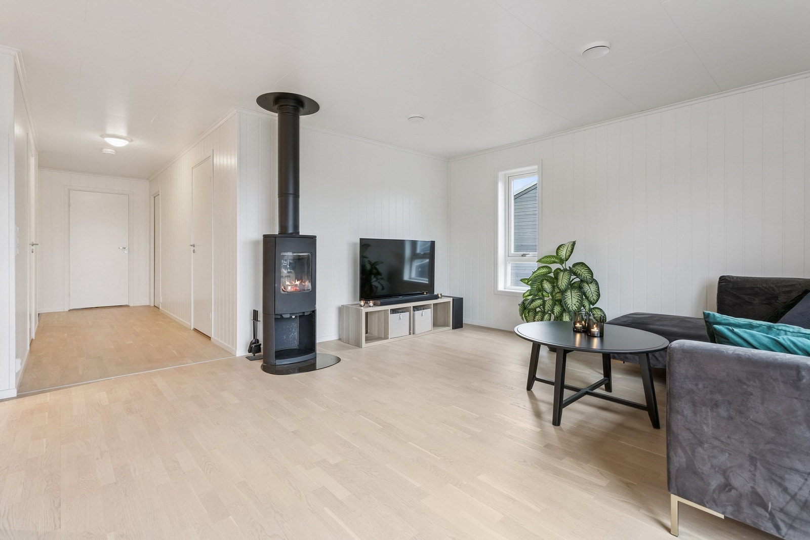 En moderne vedovn gir både effektiv oppvarming og en hyggelig atmosfære i stuen. Galleribilde