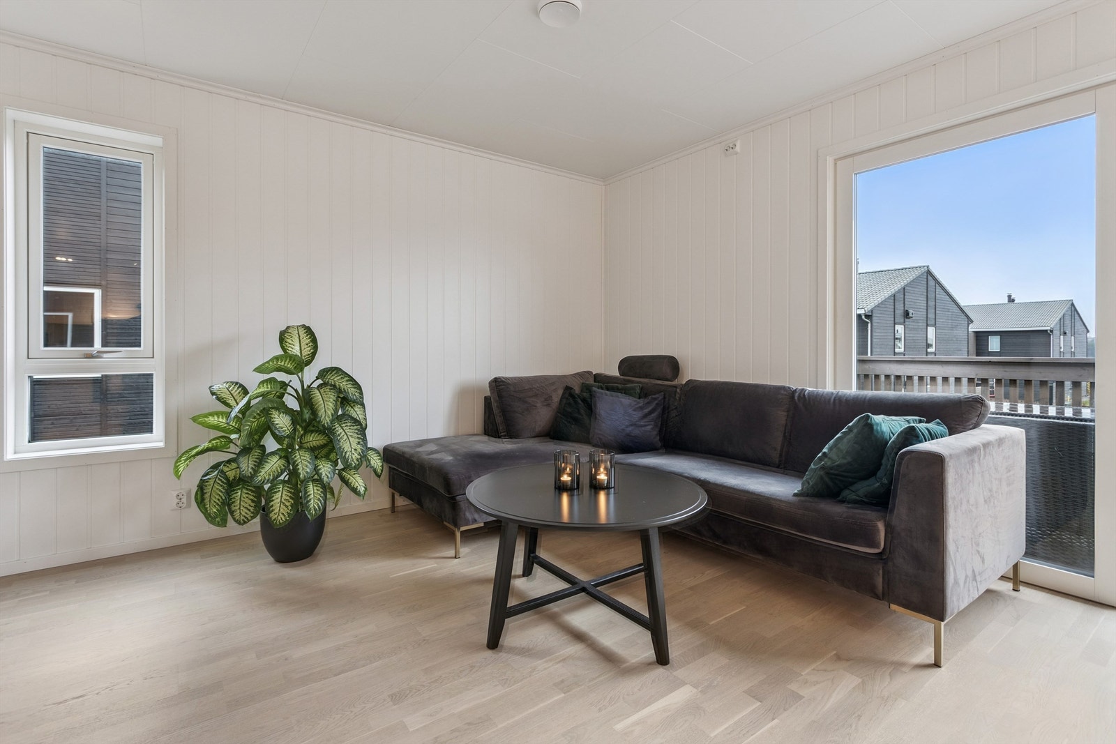 Videre inn i stuen, som har store vindusflater og gjennomgående, tidsmessige overflater. Galleribilde