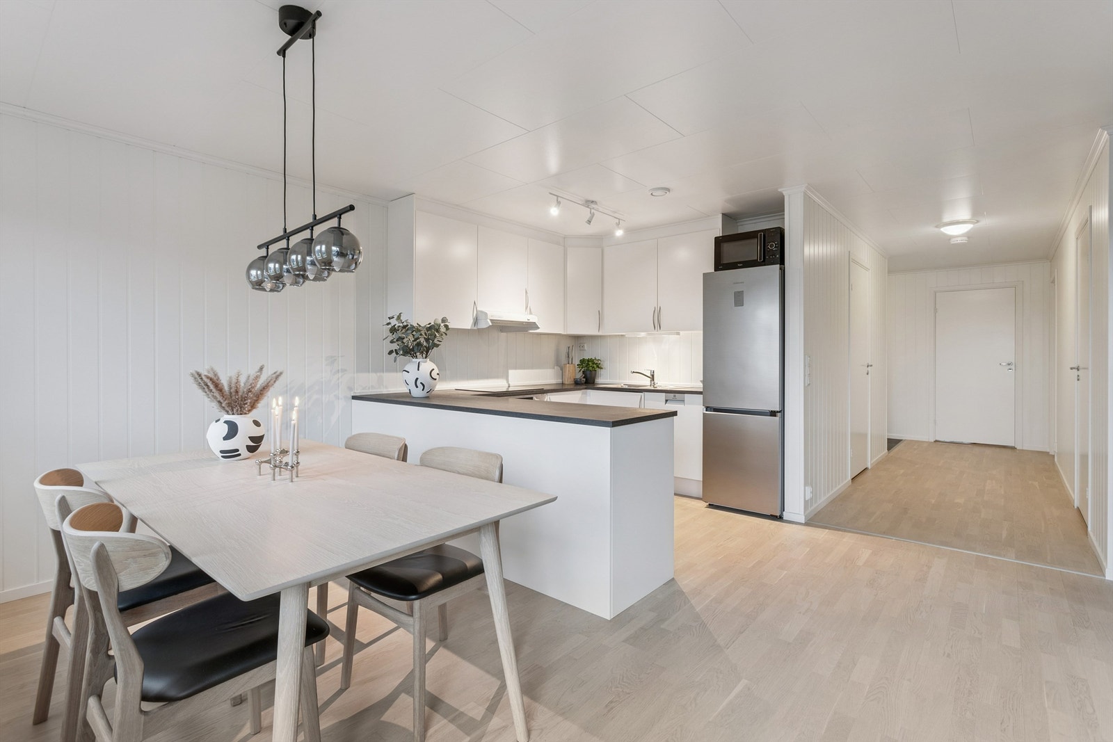 Kjøkkenet har en praktisk U-form med gode arbeidsflater og moderne, slette fronter. Galleribilde