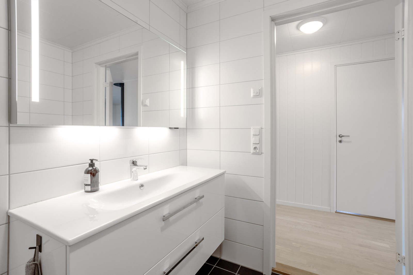 Servantinnredning med god oppbevaringsplass og speil med integrert belysning. Galleribilde