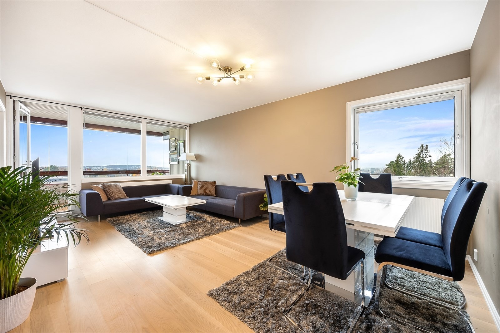 Med gjennomgående endeløsning og store vinduer oppleves stuen som lys og luftig Galleribilde