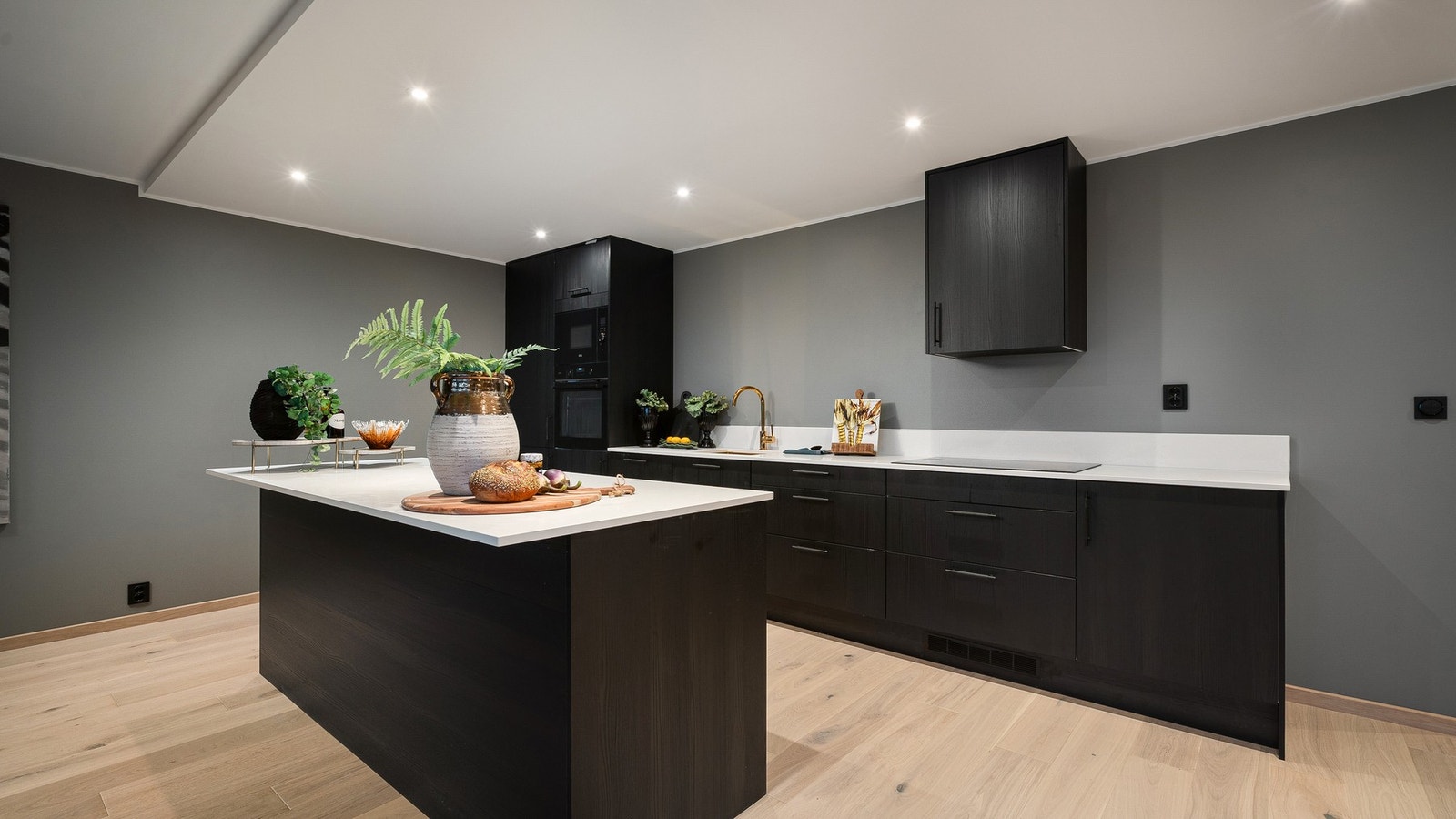 Kjøkkenøy med overheng gir plass for gjestene. Galleribilde