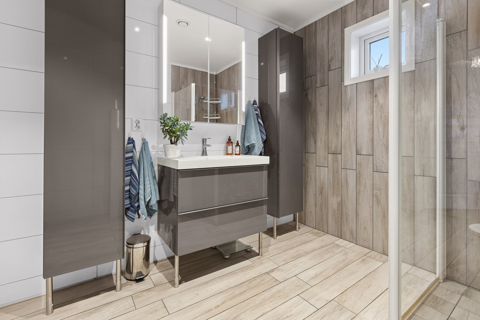 Stilren innredning med god lagringsplass. Et speil med integrert lys. Galleribilde