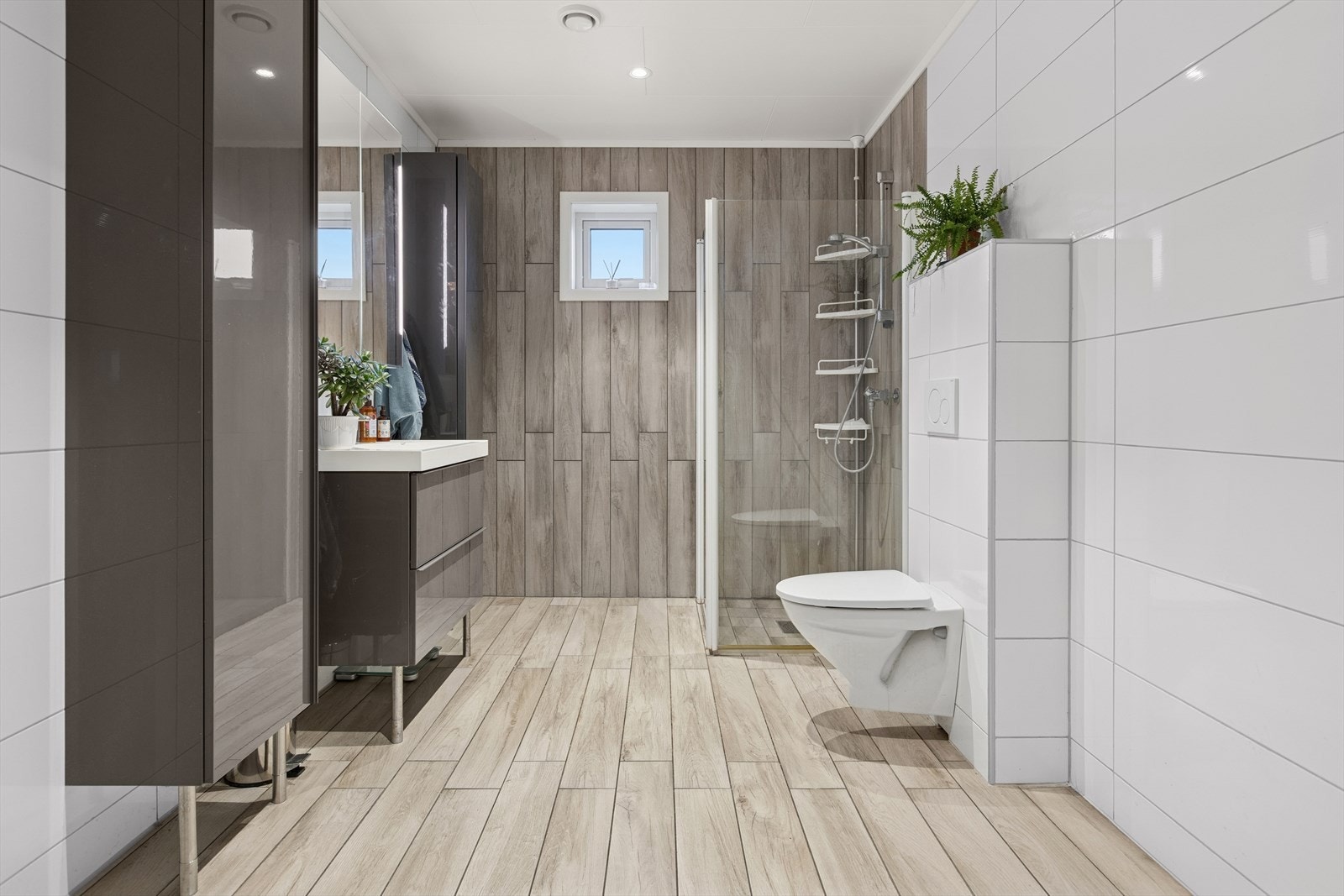 Badet fremstår moderne og funksjonelt, med lyse fliser på både gulv og vegger som gir et rent og tidløst uttrykk. Galleribilde