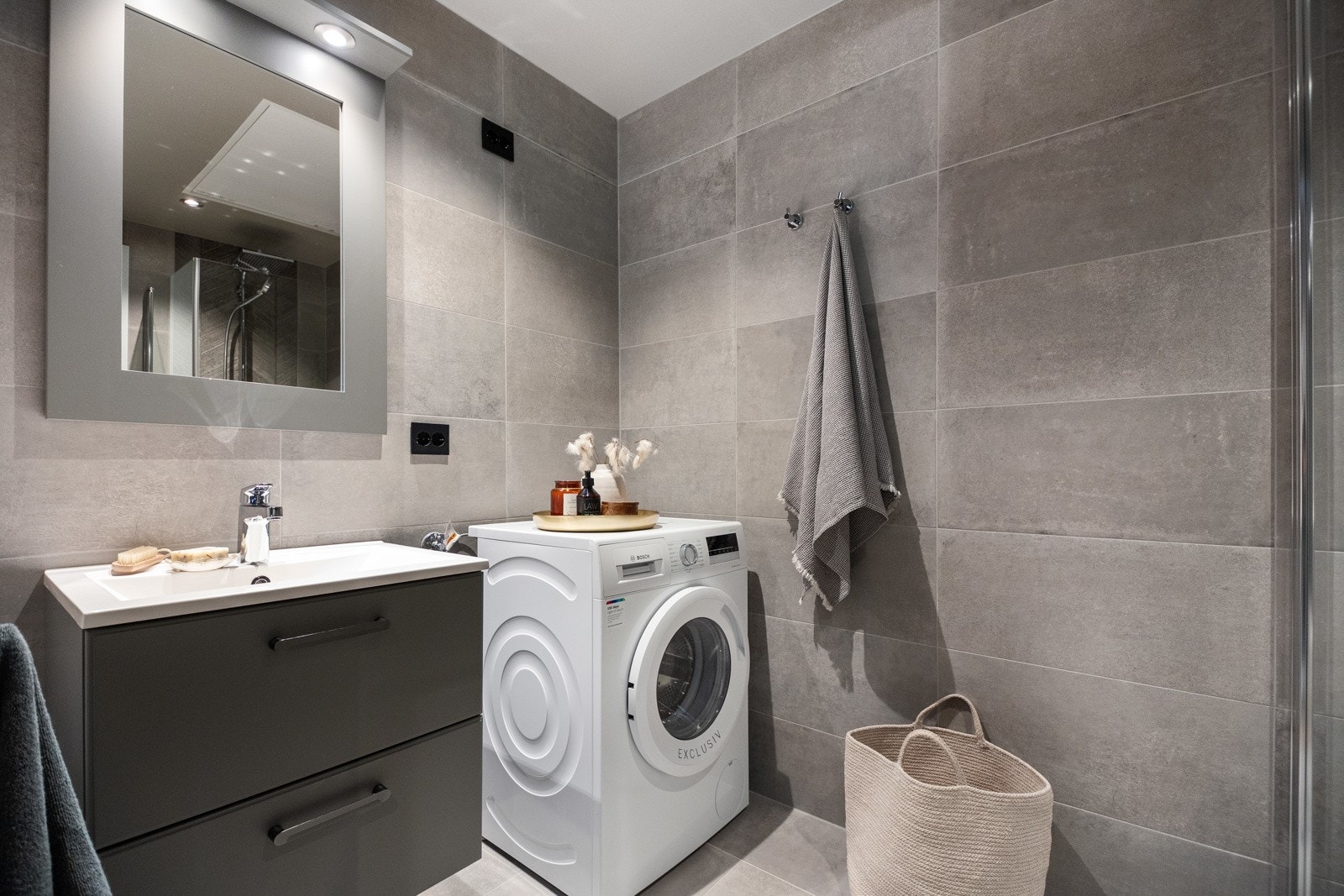 Badet har flislagte overflater med rektangulære fliser på vegger og gulv Galleribilde