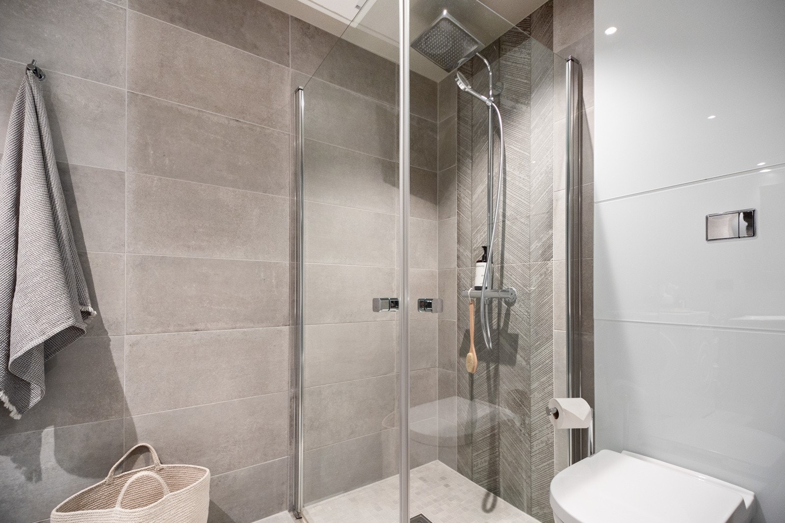 Innredning med underskuffer og nedfelt servant, toalett og dusj i ene hjørnet med glassdører Galleribilde