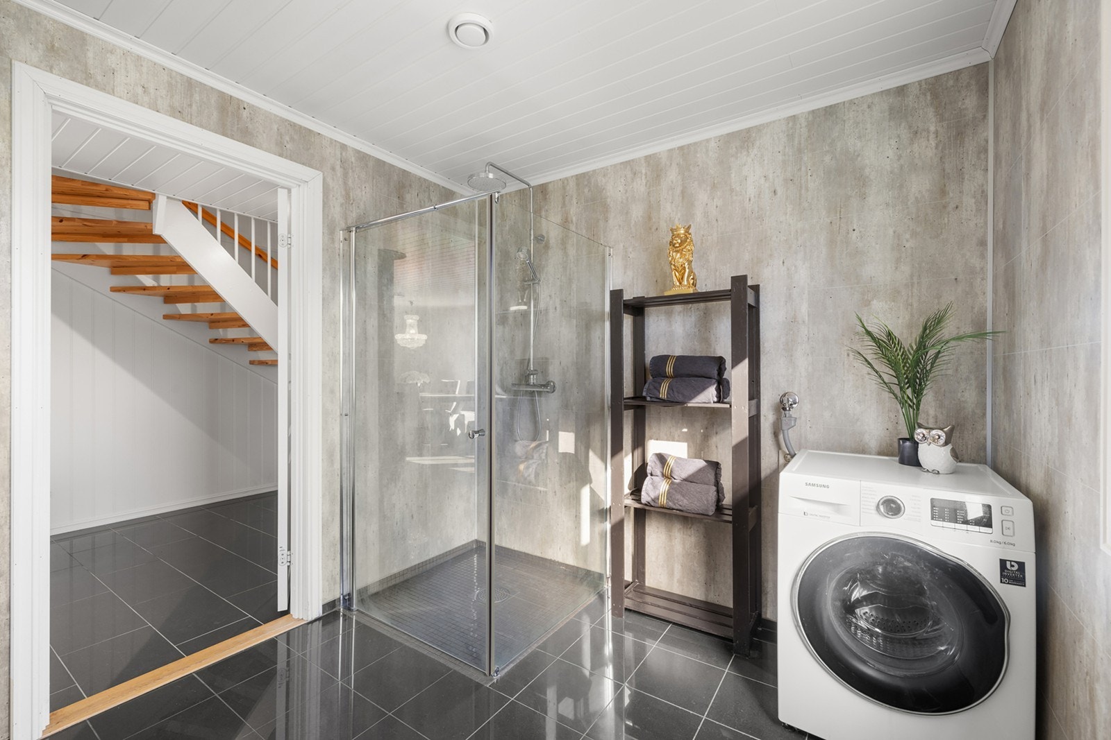 En dusjsone med regnfallsdusj og innfellbare dusjvegger. Videre har badet opplegg for vaskemaskin, vannklosett og vindu. Galleribilde