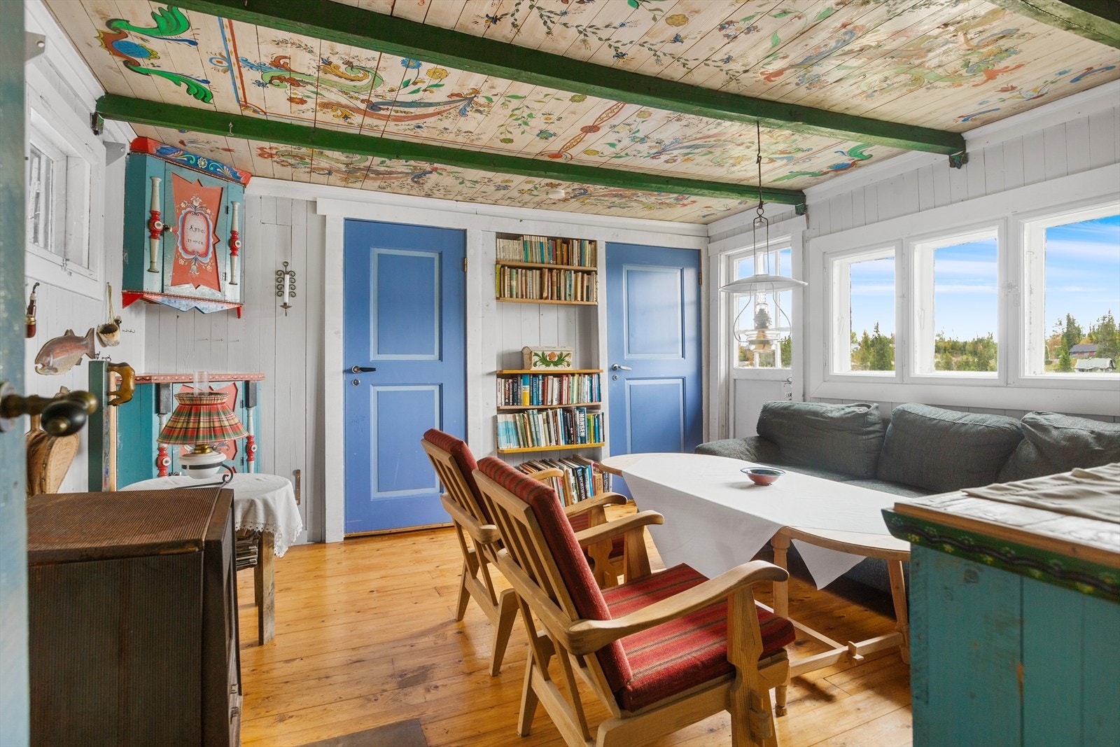Inne i hytta er det sjarmerende malerier bla. i tak, på dører og skap, og i stua er det mange vinduer, samt terrassedør med glassfelt, som lar en nyte utsikten utover vannet. Galleribilde