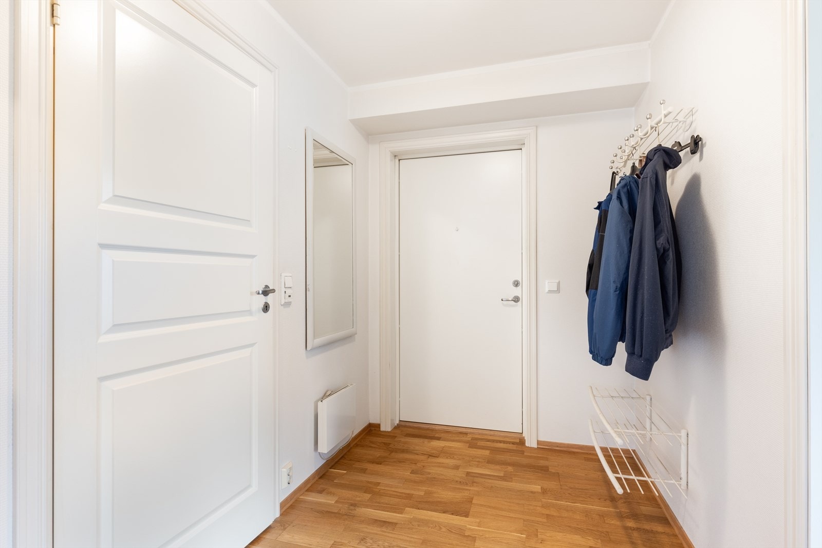 Med adkomst fra felles trappegang kommer man inn i den lyse entréen med parkett på gulvet som går videre inn i leiligheten og gir en fin helhet. Entré med plass til sko og oppheng av yttertøy. Galleribilde
