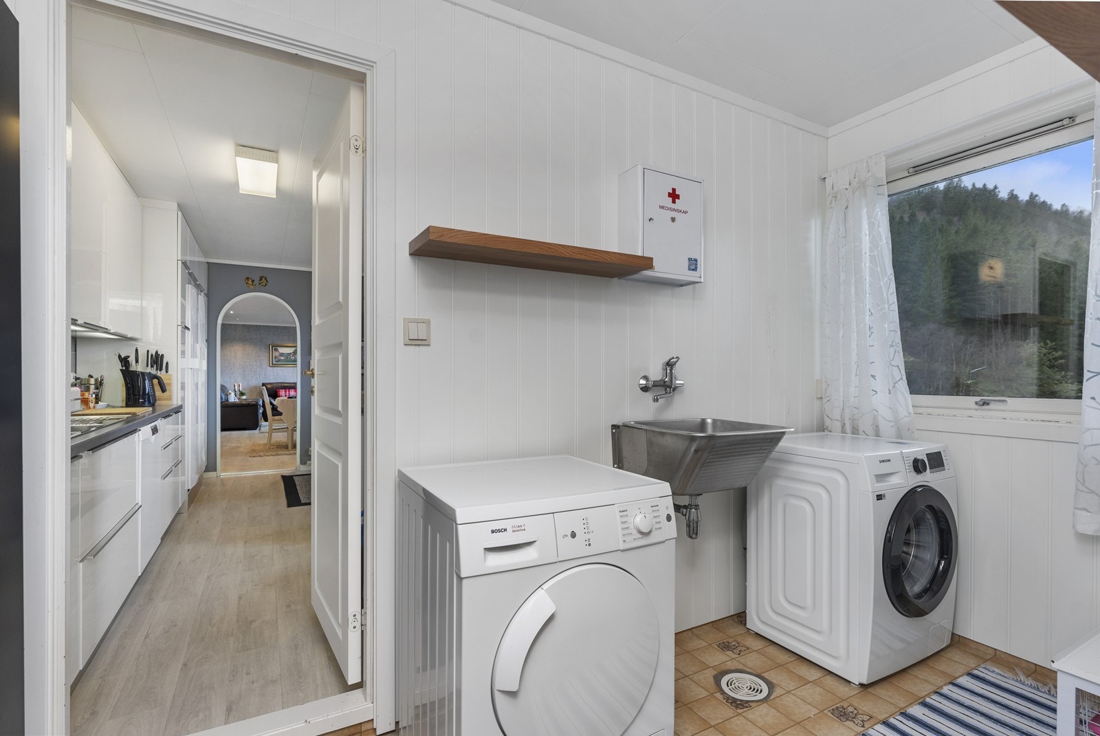 Fra kjøkkenet ankommer man boligens vaskerom Galleribilde