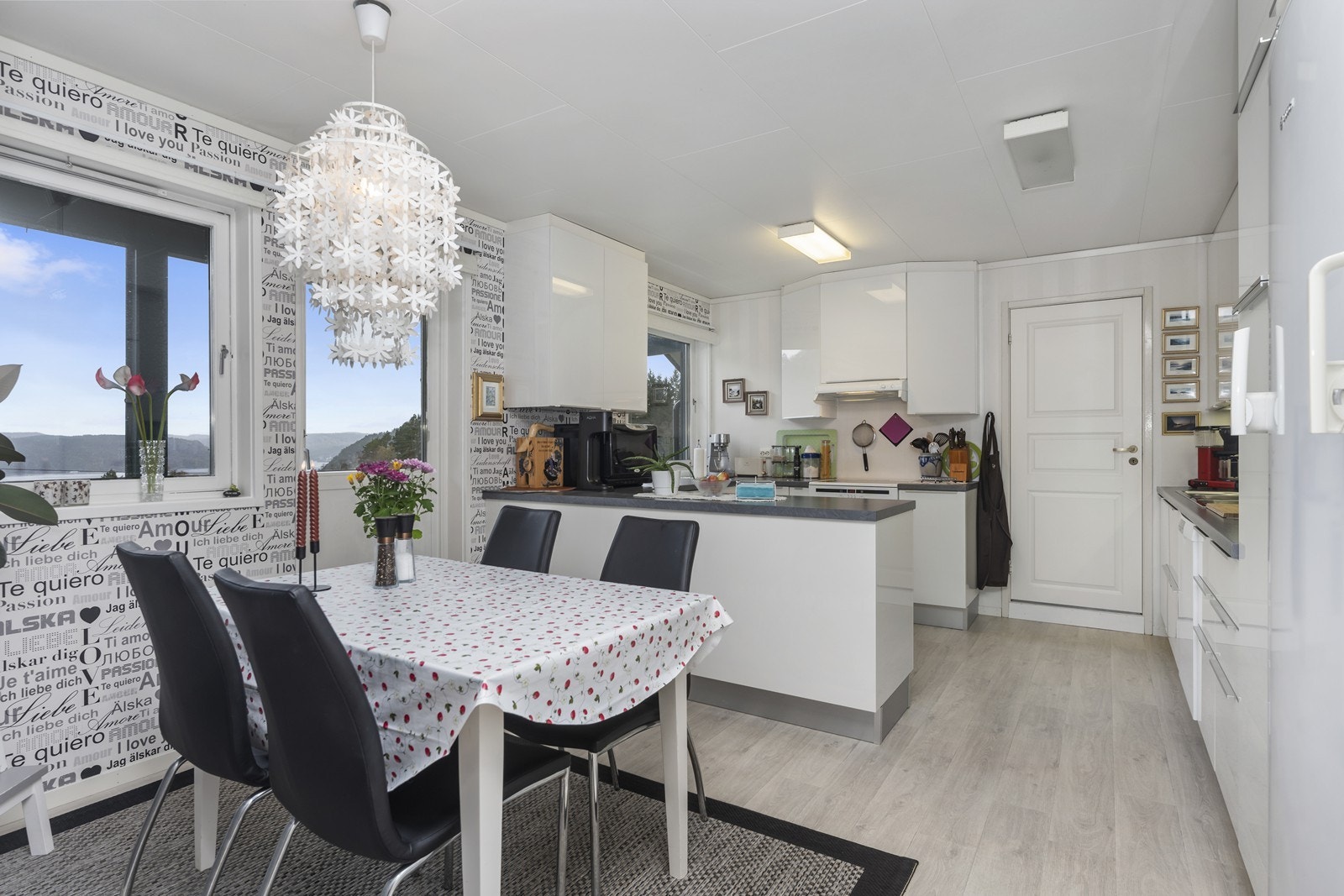 Lyst kjøkken med slette fronter og integrerte hvitevarer Galleribilde