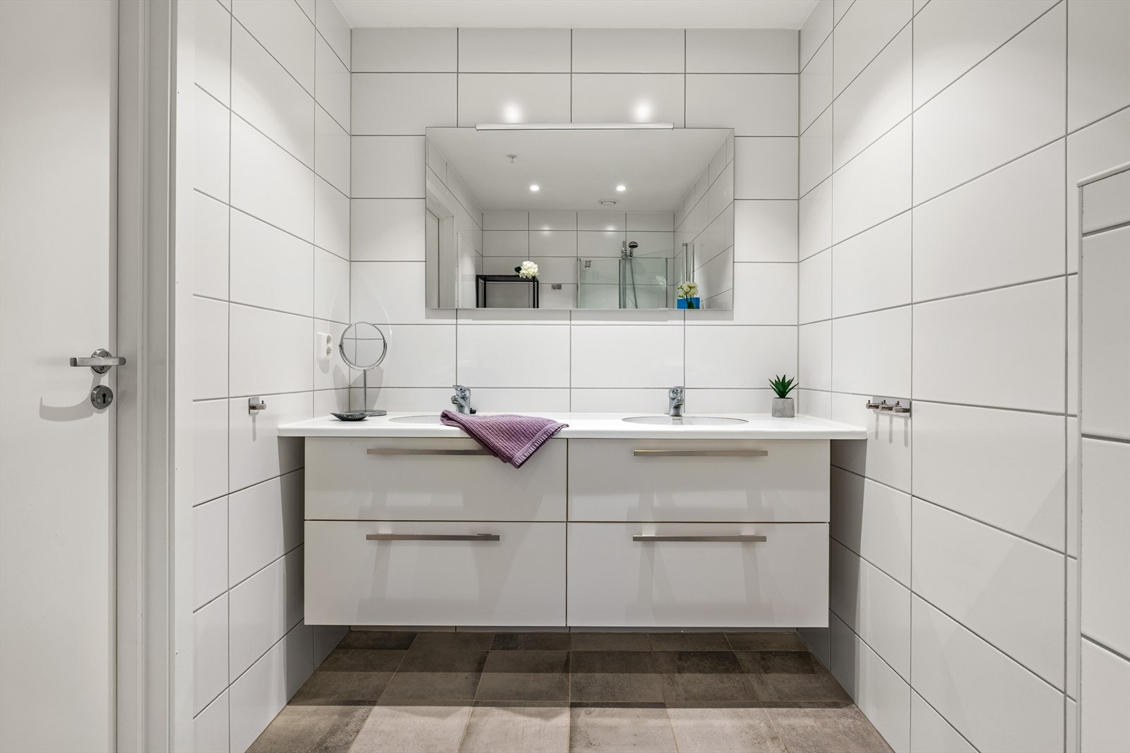 Lyst og romslig bad med delikate fliser på gulv og vegger Galleribilde