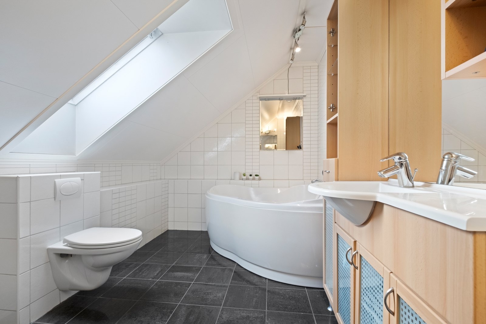 Skråtak med velux-vindu gir naturlig lysinnslipp på badet Galleribilde