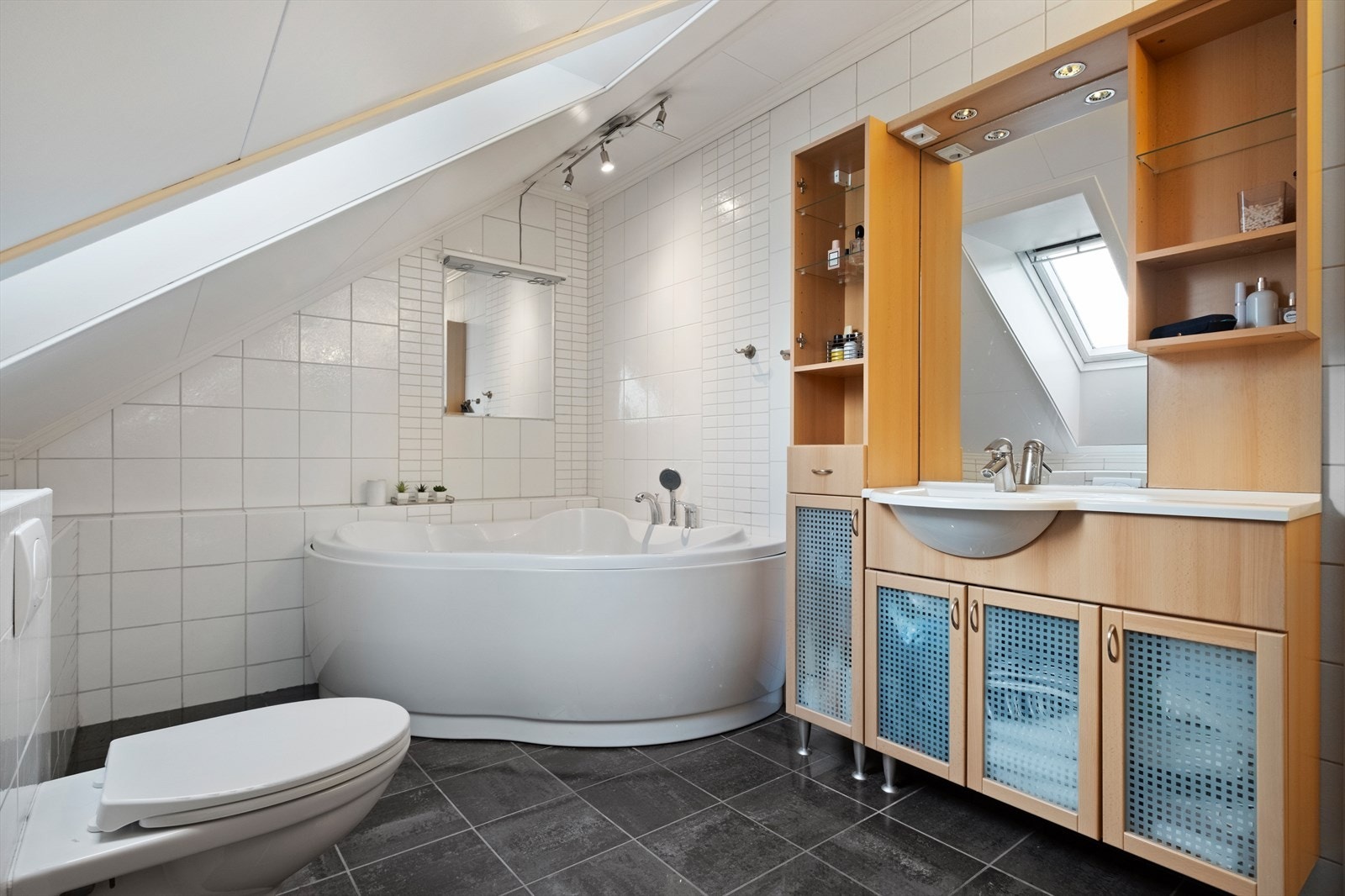 Badekar og veggmontert toalett gir et komfortabelt våtrom på loftet Galleribilde