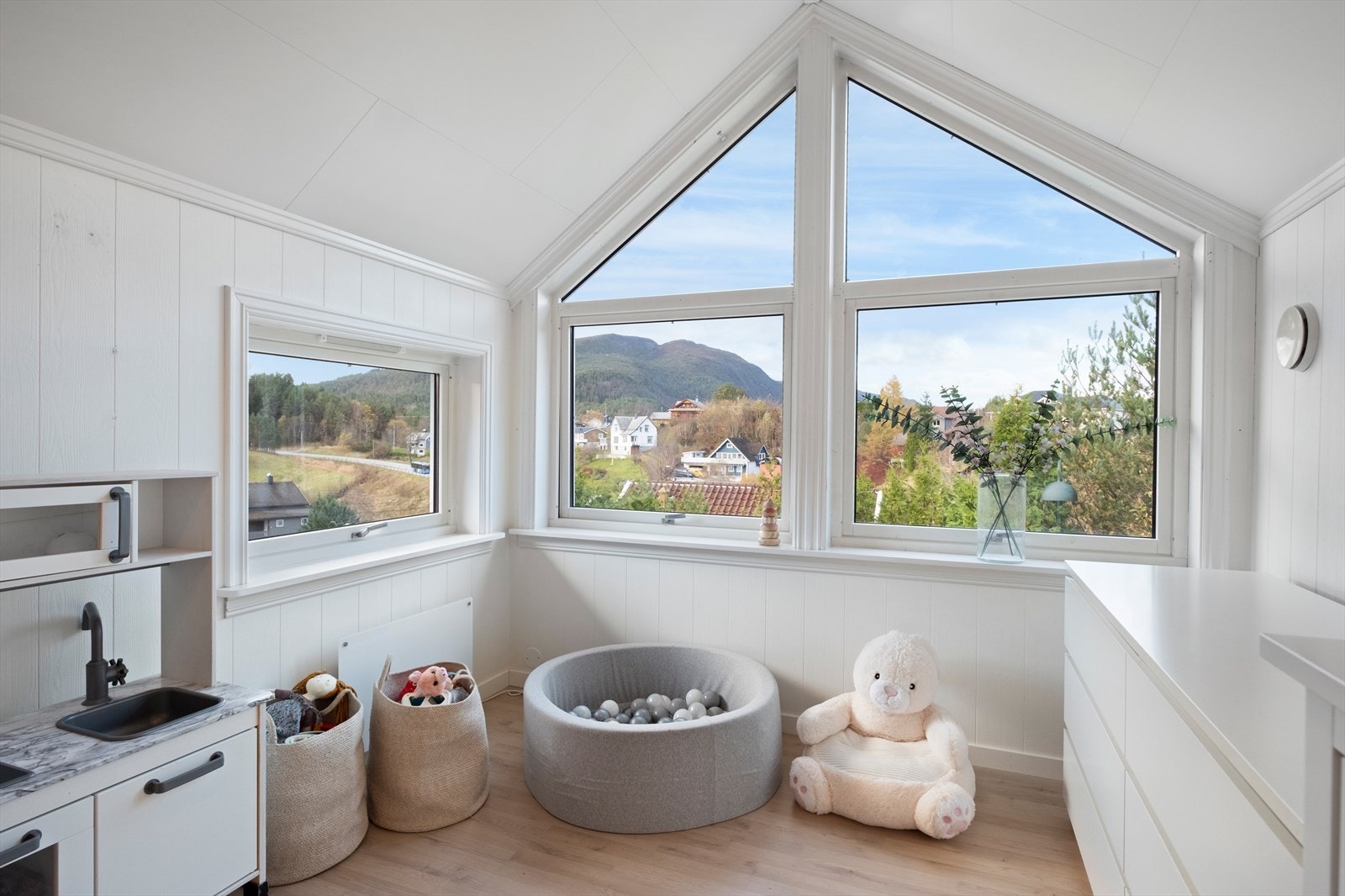 Store vindusflater gir utsikt mot grøntområder og fjell. Galleribilde