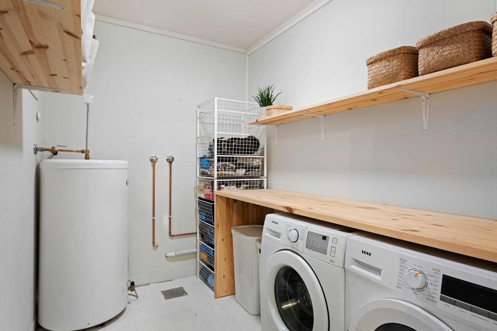 Rommet har flislagt gulv og elektriske varmekabler, som gir en komfortabel opplevelse. Vaskerommet er utstyrt med opplegg for vaskemaskin, tørketrommel og en varmtvannstank Galleribilde