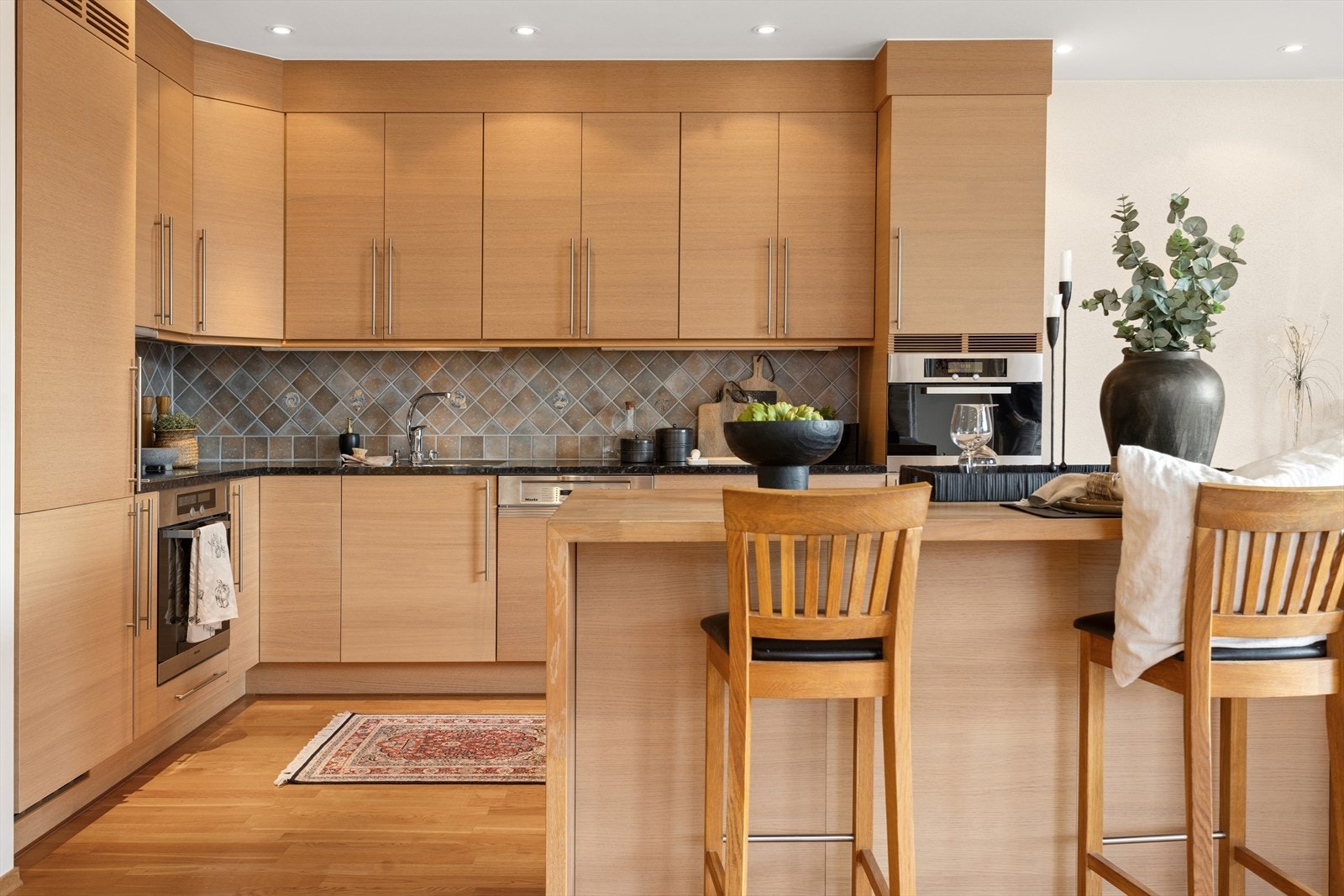 Integrerte hvitevarer og mekanisk avtrekk sikrer et funksjonelt kjøkkenmiljø. Galleribilde