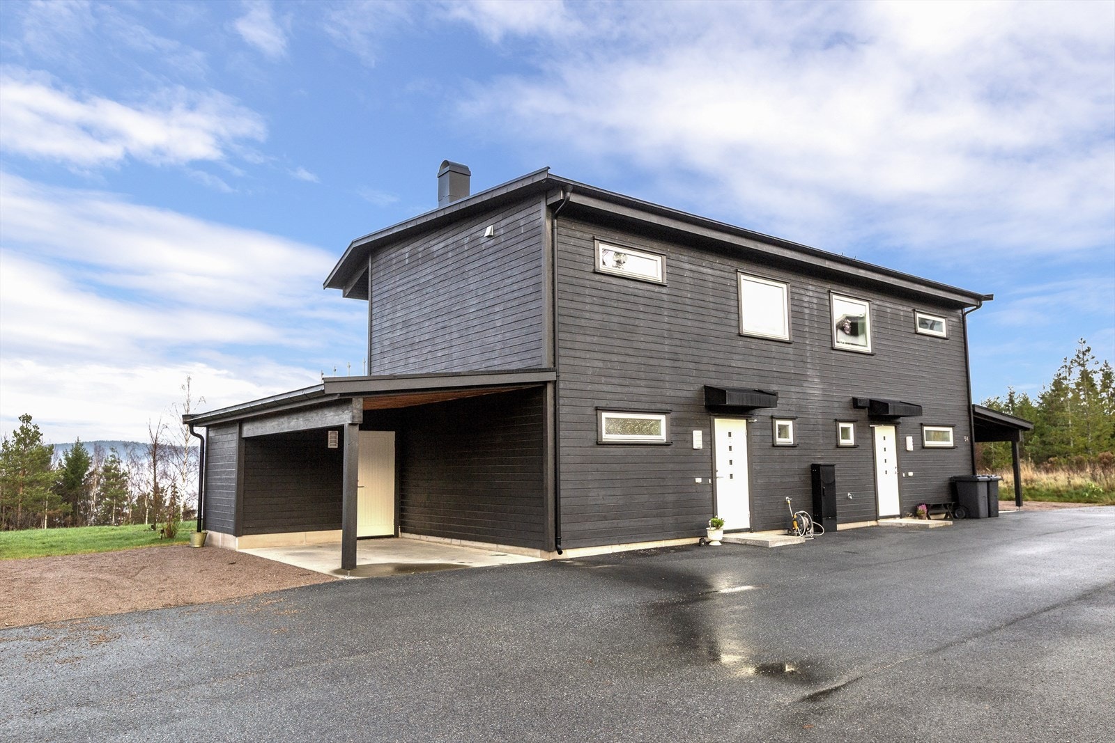 Parkering i carport med tilknyttet sportsbod. Gode parkeringsmuligheter på asfaltert gårdsplass Galleribilde