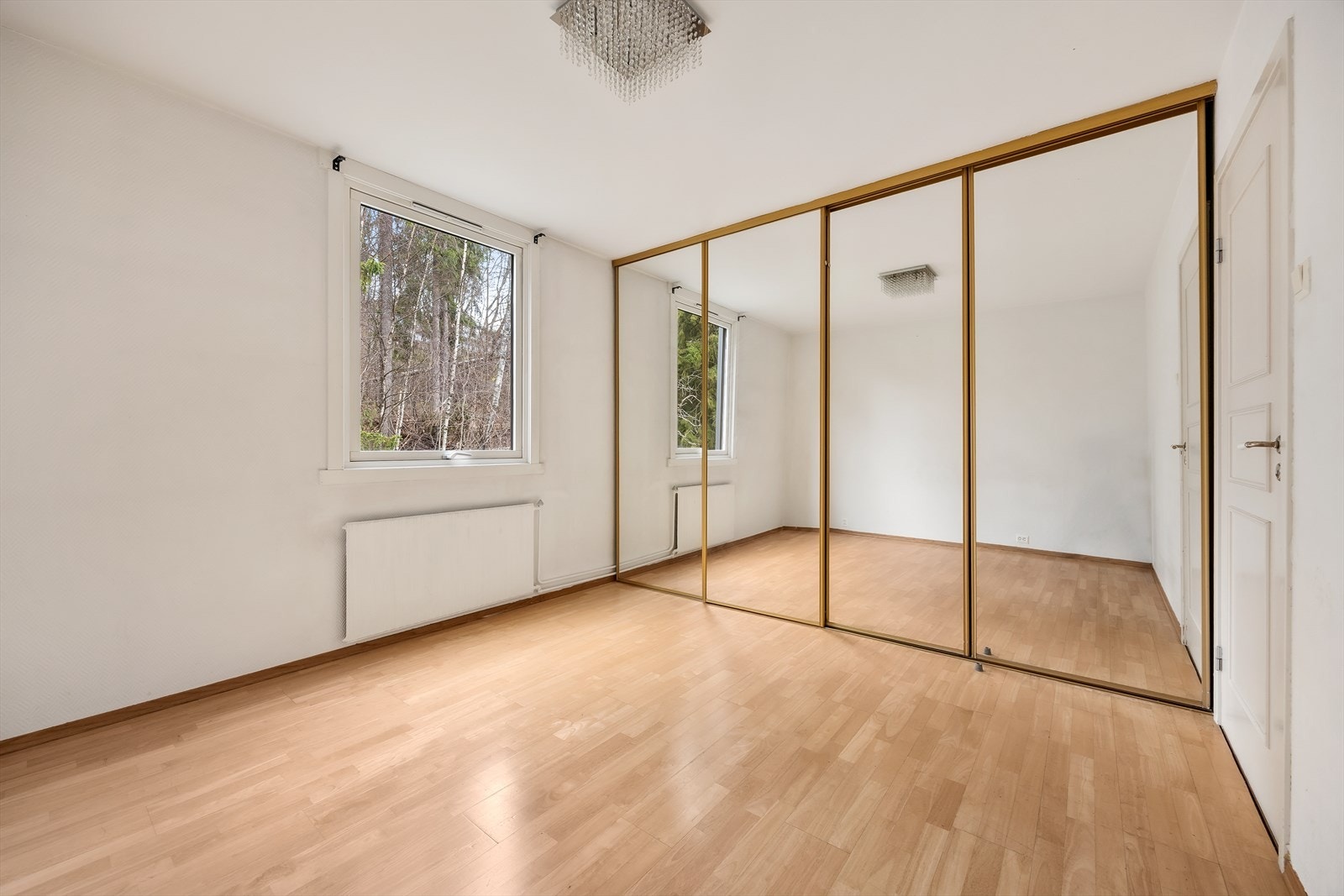 En stor skyvedørsgarderobe med speilfronter gir rikelig med oppbevaringsplass. Galleribilde