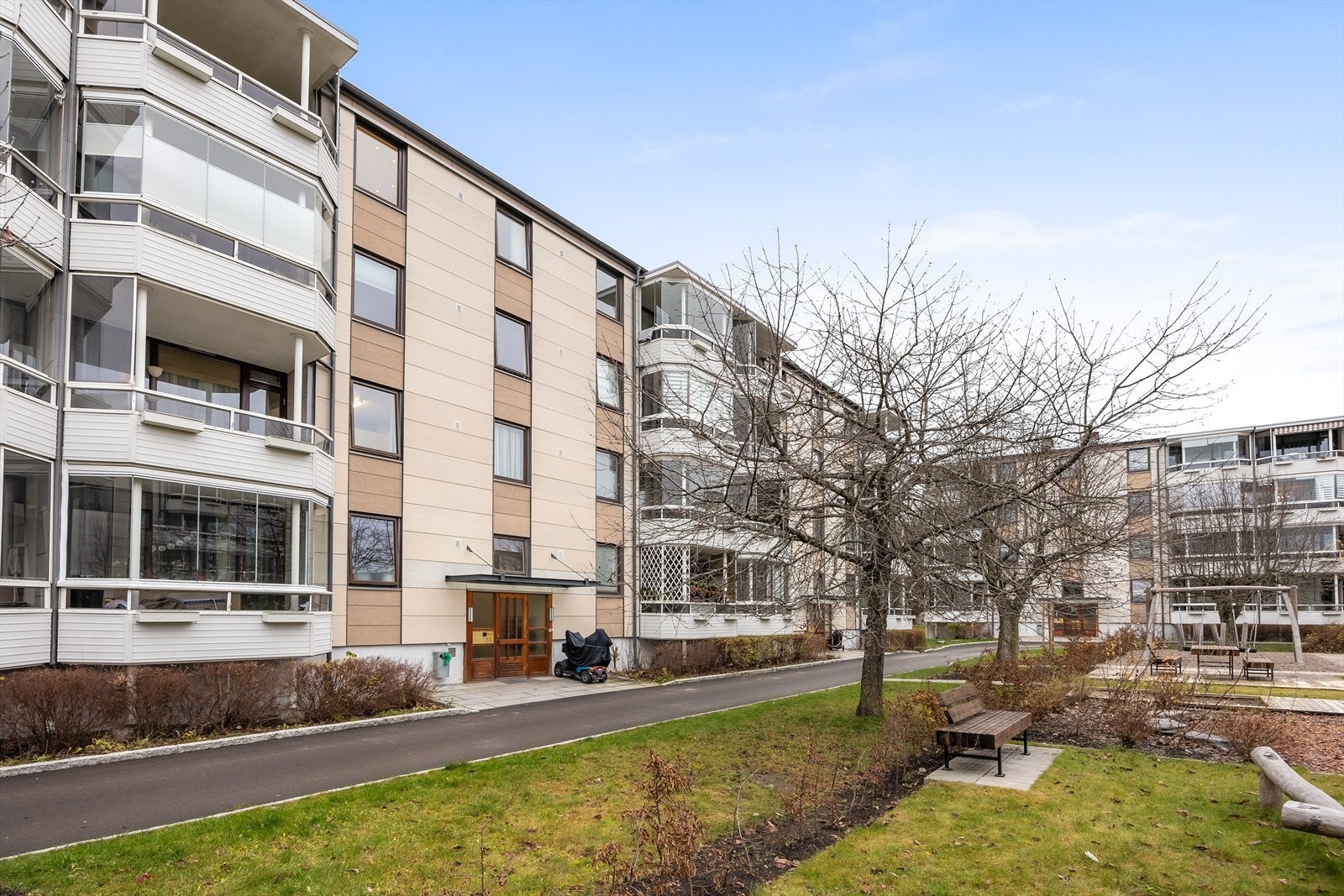 Eiendommen er tilbaketrukket fra trafikk, med velholdte grøntarealer mellom byggene. Galleribilde