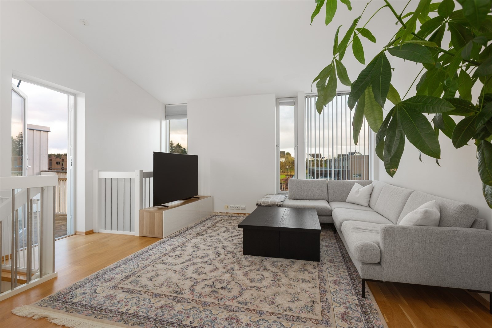 Romslig stue med store vindusflater og utgang til solrik terrasse. Galleribilde