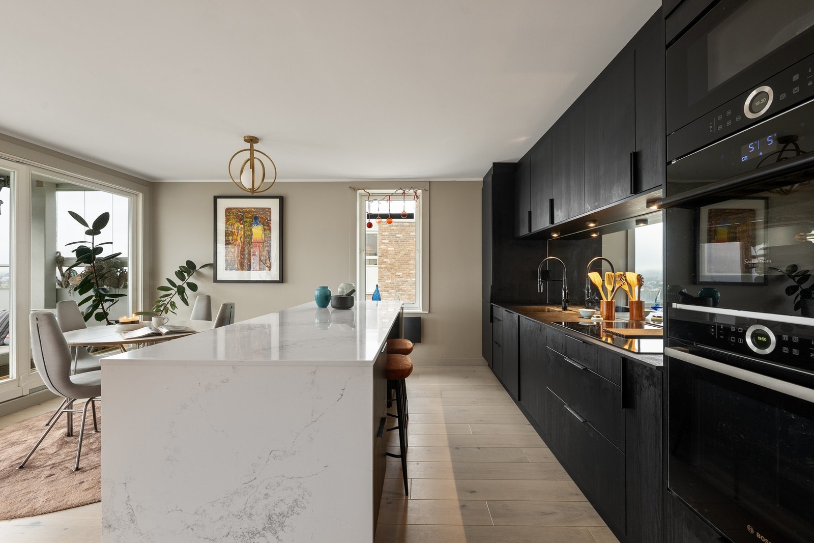 Stor kjøkkenøy med steinbenkeplate, god oppbevaringsplass, romslig arbeidsflate og praktisk bardiskløsning. Galleribilde