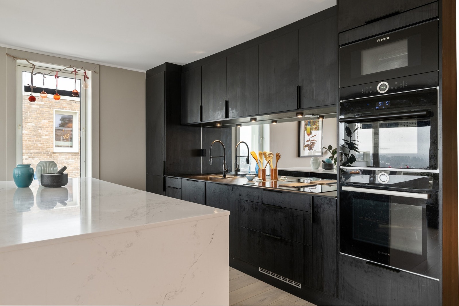 Integrert mikrobølgeovn, stekeovn og vinskap er plassert samlet i høyskap. Galleribilde