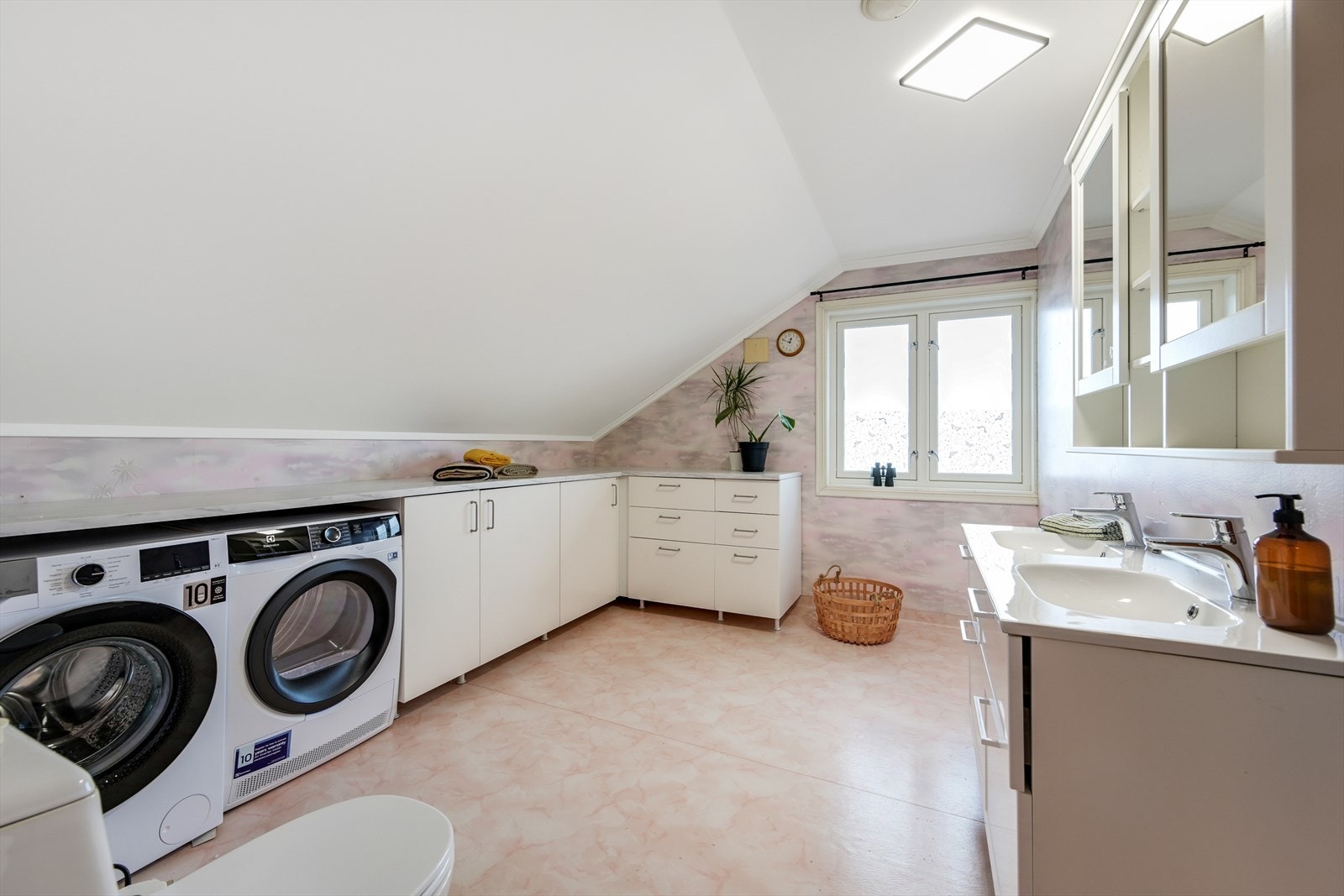 Romslig bad med opplegg til vaskemaskin. Belegg på gulv, tapet på veggene og malt tak. Galleribilde