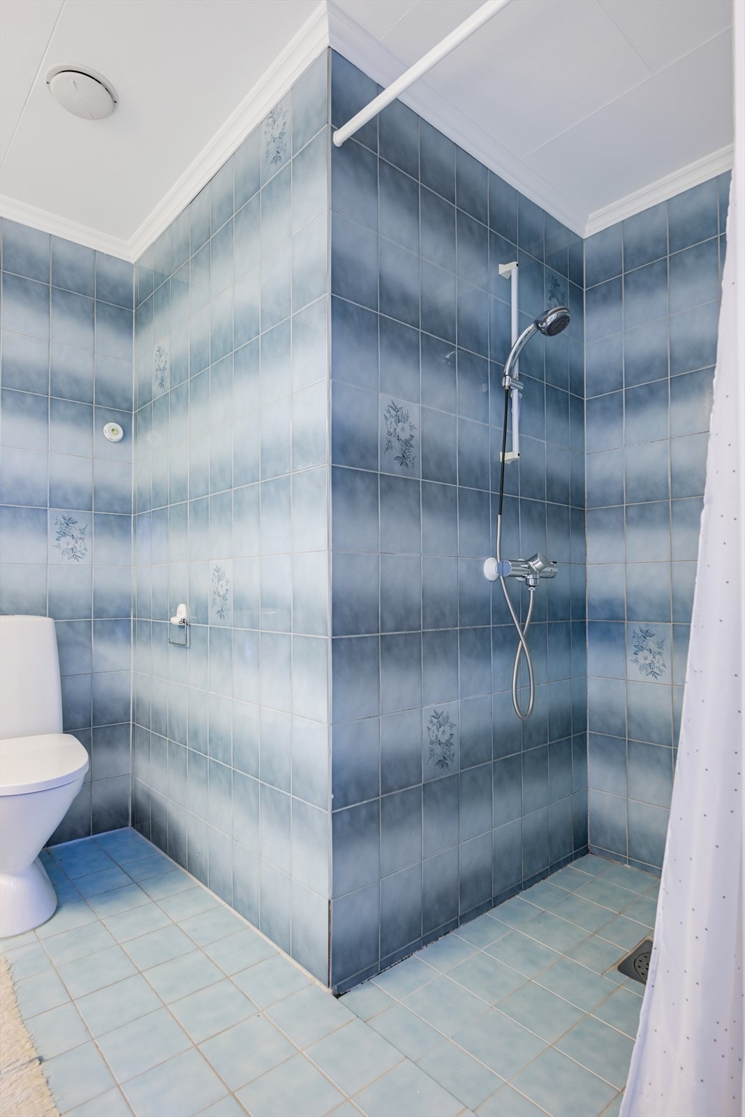 Badet har fliser på gulv og vegger, og takess i taket. Galleribilde