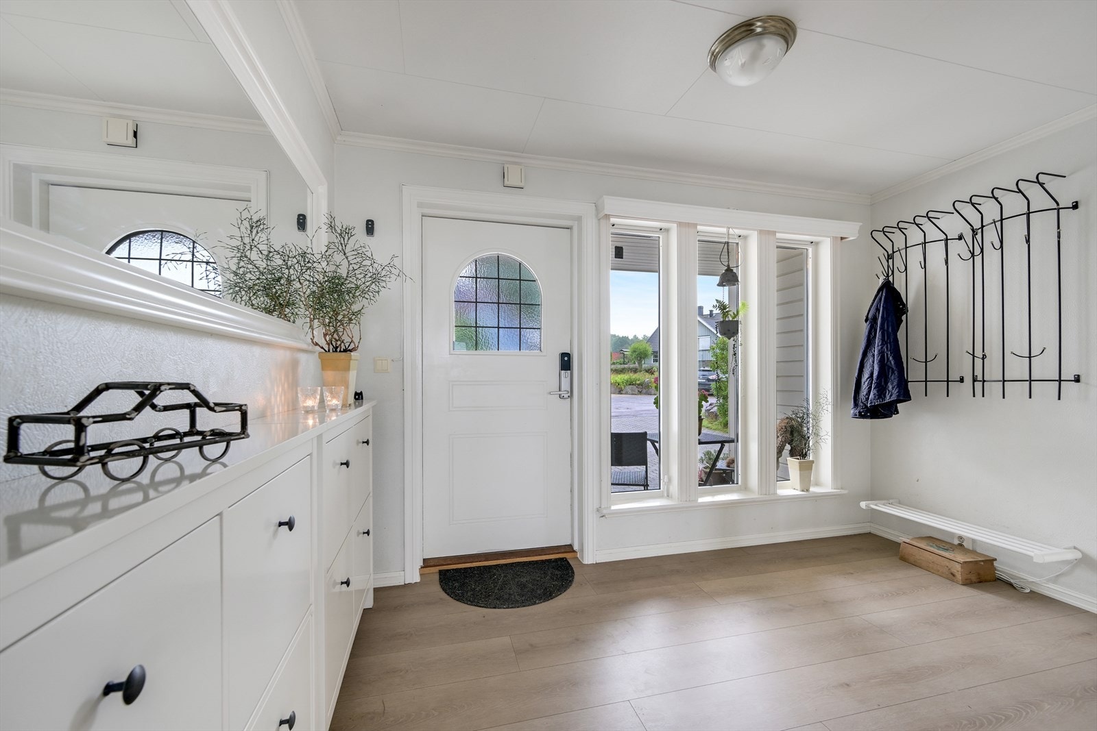 Romslig hall/entré i hovedetasjen med utgang til overbygget inngangsparti. Galleribilde