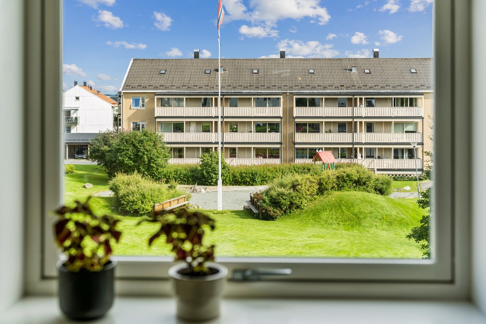 Fra kjøkkenet er det flott utsikt over borettslagets fine fellesområder. Galleribilde