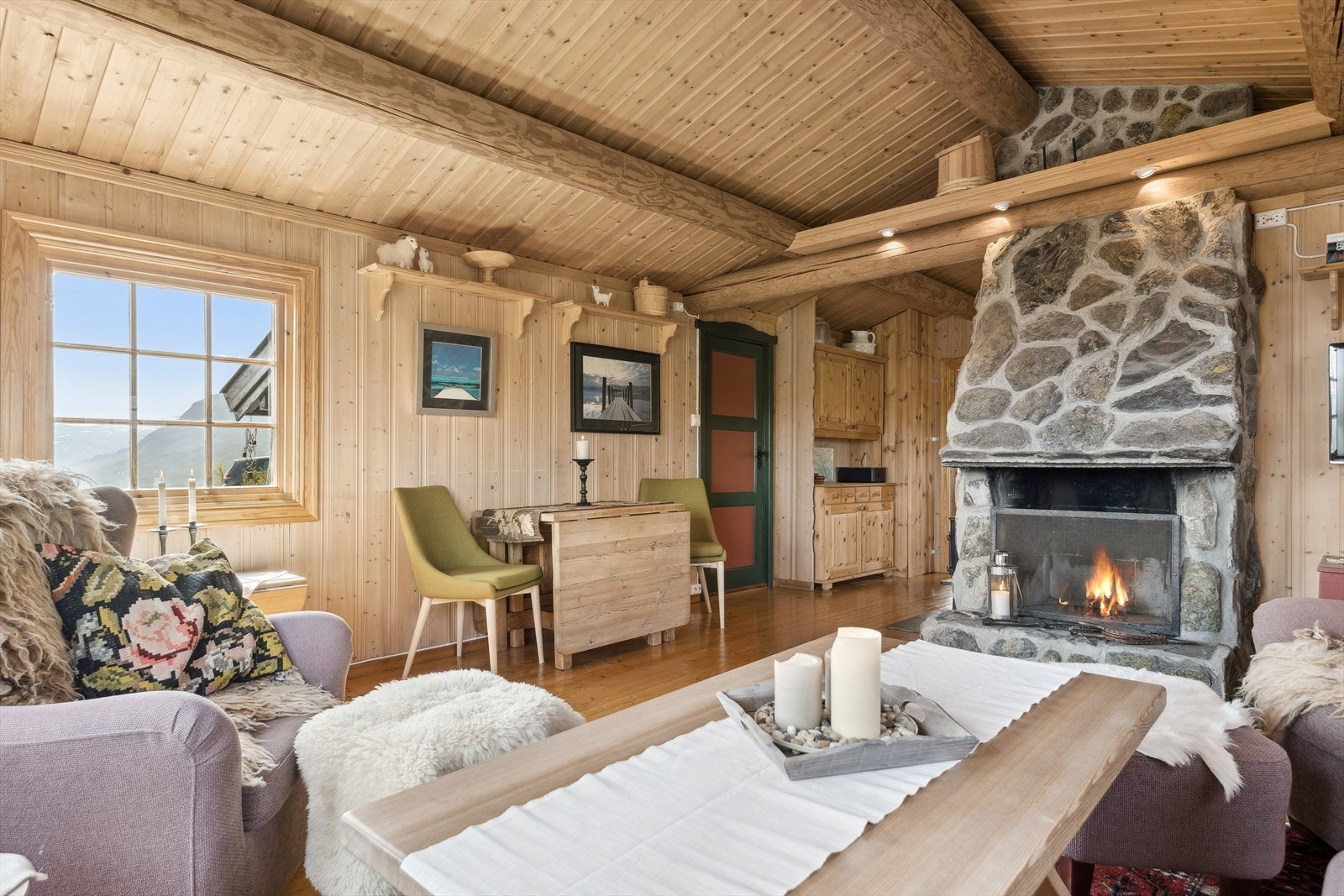 Nær peisen, mot kjøkken, er det en Jøtul vedovn som gir lun og god varme. Galleribilde