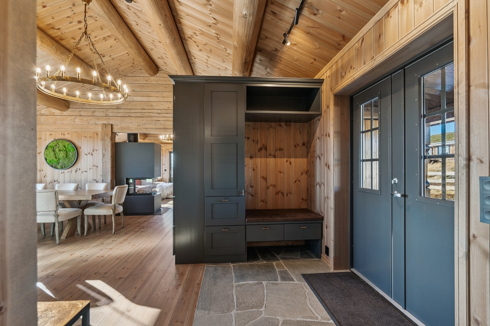 Fra det overbygde inngangspartiet ønskes du velkommen inn gjennom en to-fløyet ytterdør til en åpen entré. Her er det fliser med varmekabler på gulvet. Galleribilde