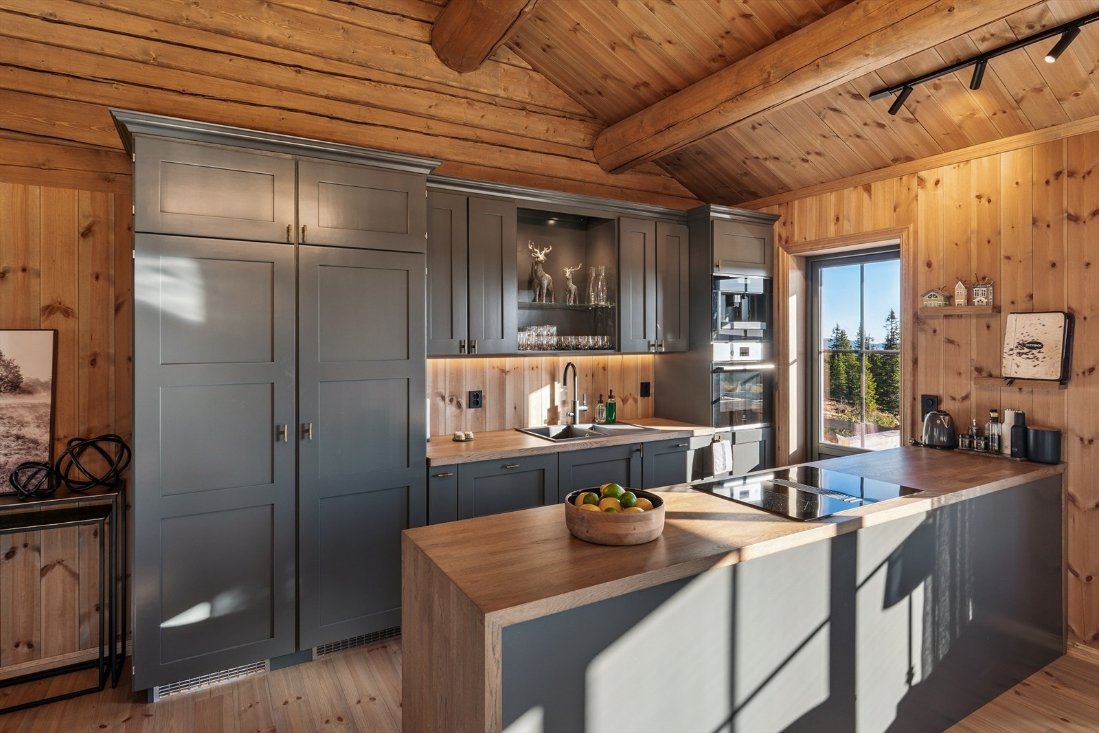 Kjøkkenet er både stilrent og praktisk, med innredning i heltre, eik benkeplate med nedfelt oppvaskkum av komposittmateriale samt vitrineskap som gir rommet karakter. Galleribilde