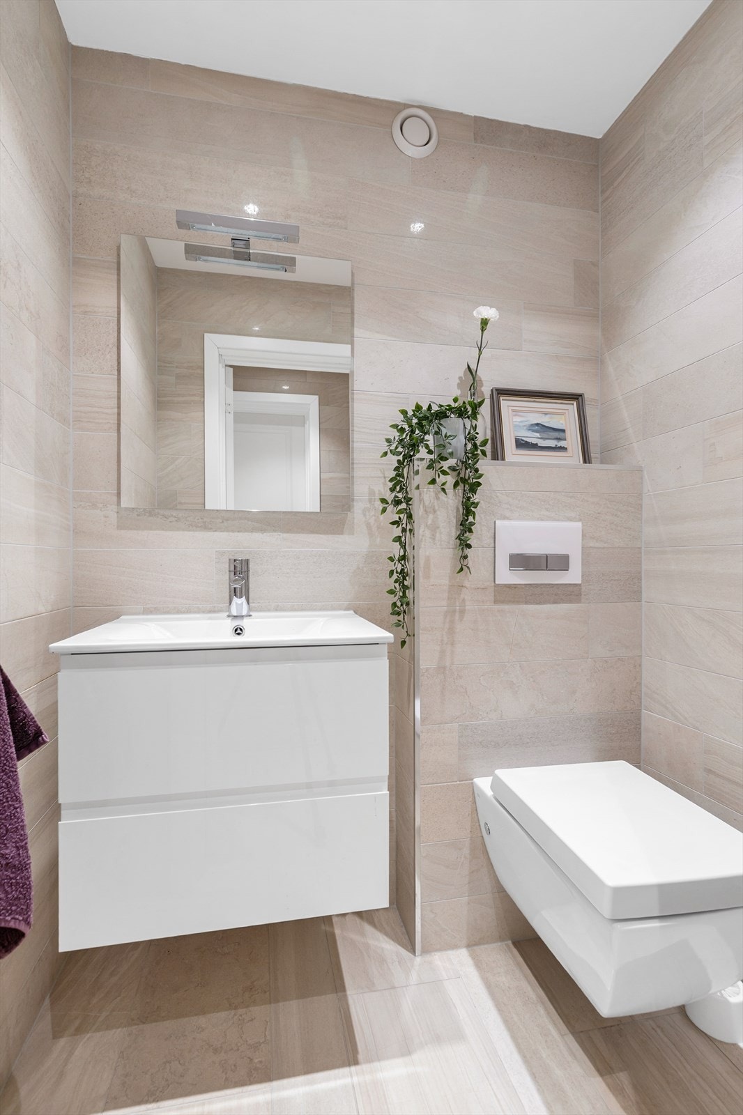 Toalettrom fra 2012. Flislagt gulv med gulvvarme. Flislagte vegger. Nedsenket himling med downlights. Vegghengt servantinnredning med skuffer. Ovenpåliggende servant med ett-greps armatur. Naturlig avtrekksventil på vegg. Galleribilde