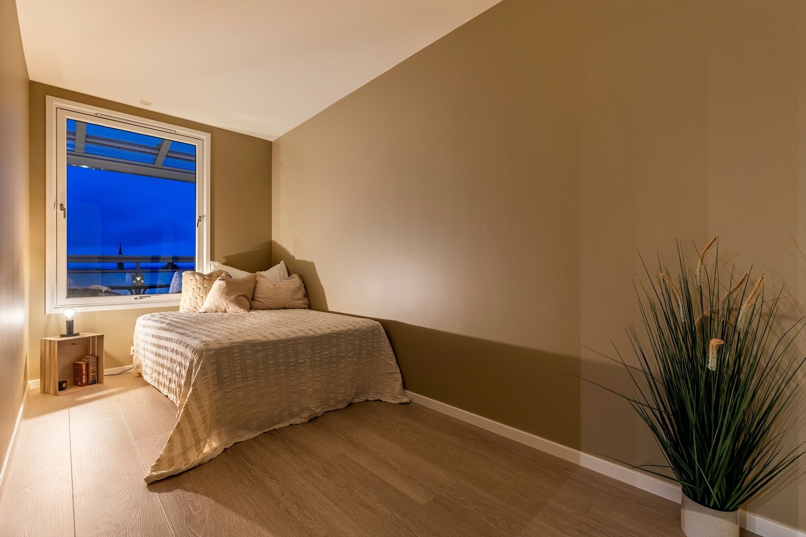 Rommet har vindu med utsikt, enstavs laminat på gulvet og vegger i en moderne, lun farge. Galleribilde